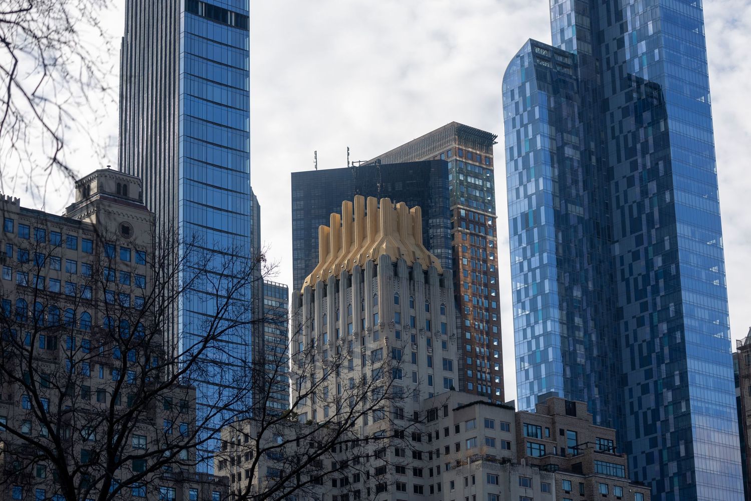 Contemporary glass skyscrapers and classic architecture blend in Manhattan's skyline against a blue winter sky.