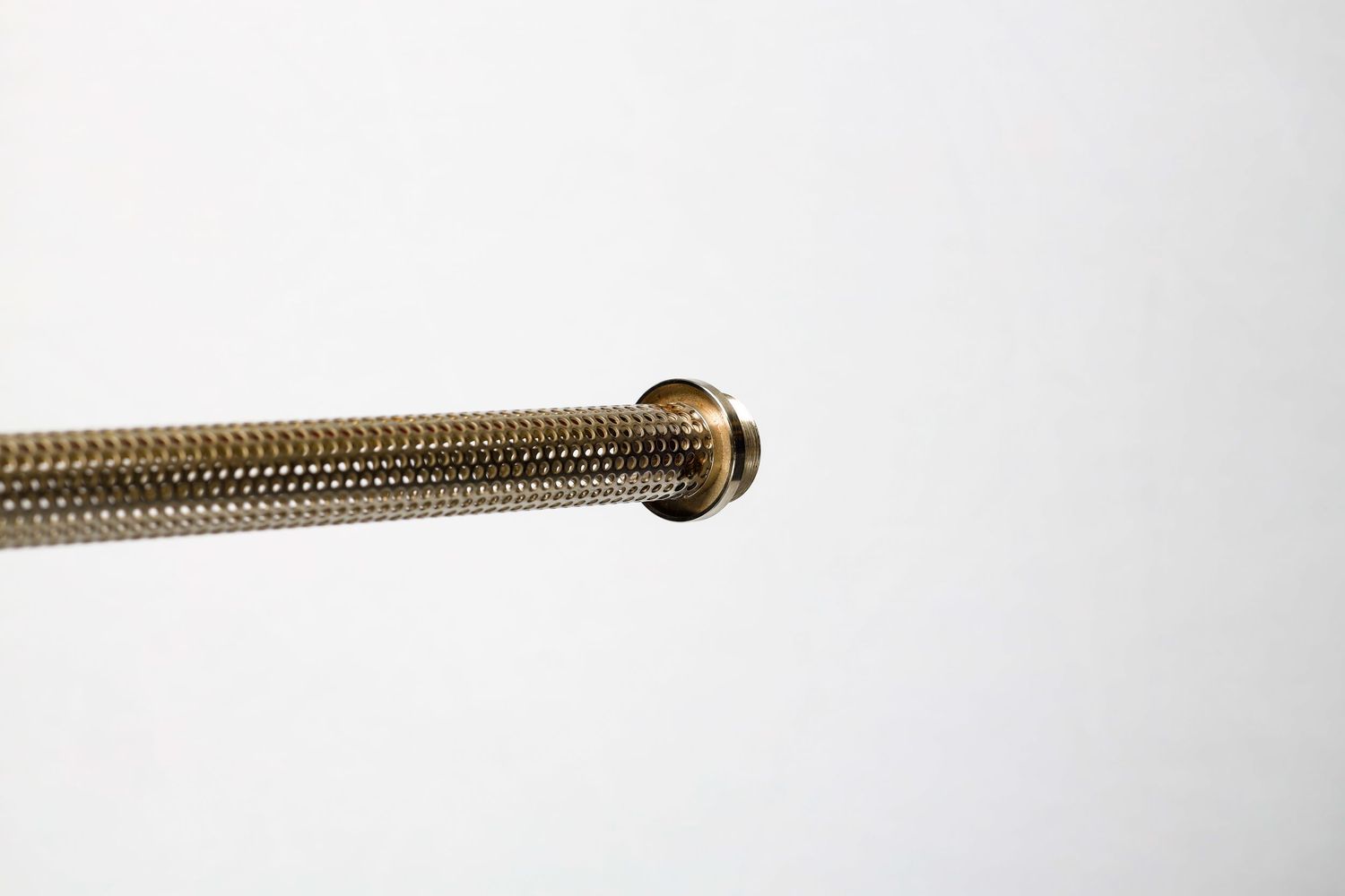 Close-up view of a gold braided metal hose or flexible cable against a white background.