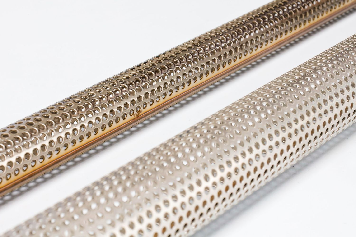 Close-up of metallic perforated tubes showing detailed industrial pattern.