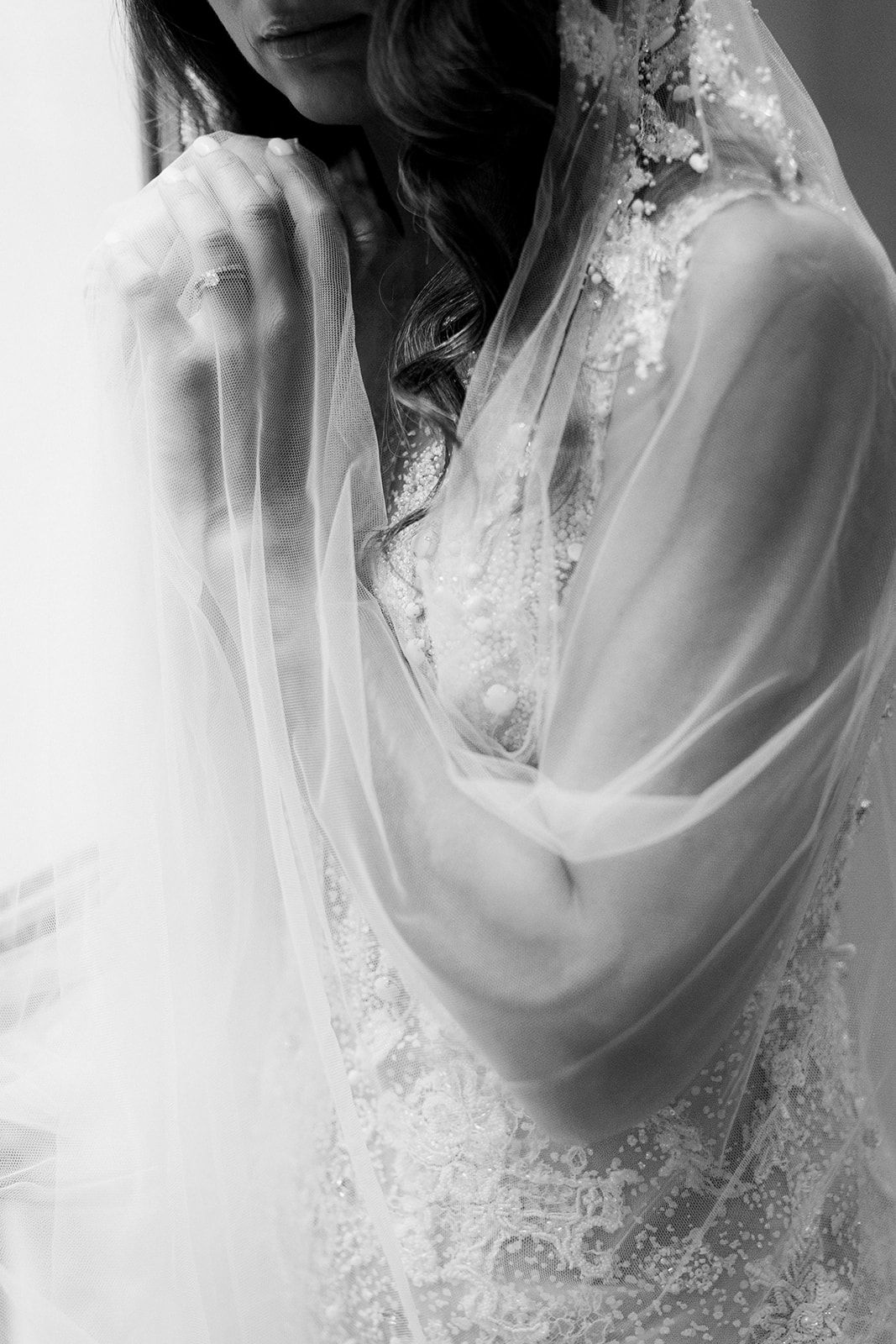bride in her wedding gown with the veil covering her