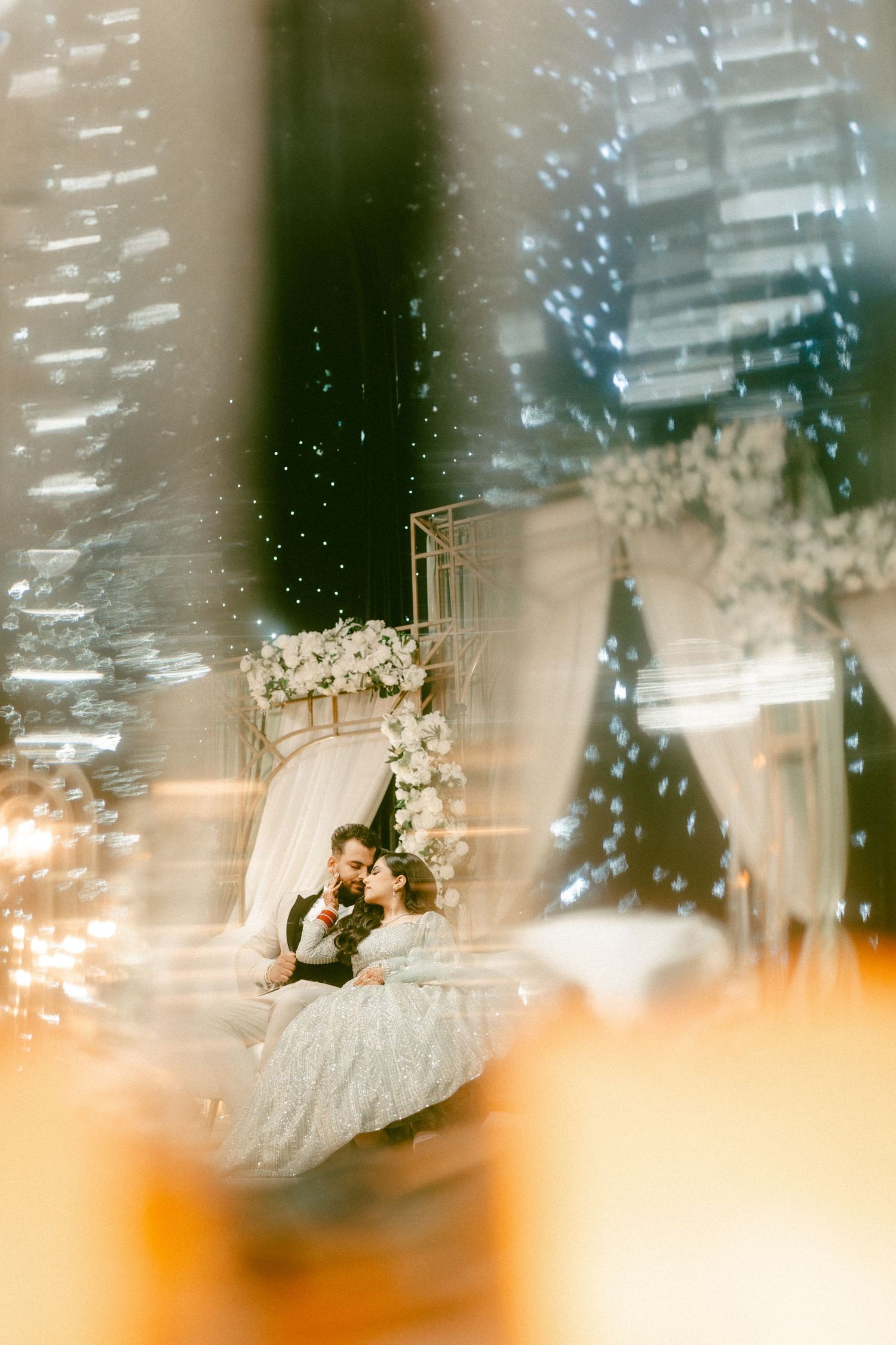 Dreamy wedding scene with decorative floral arch and soft bokeh lighting effects creating a romantic atmosphere.