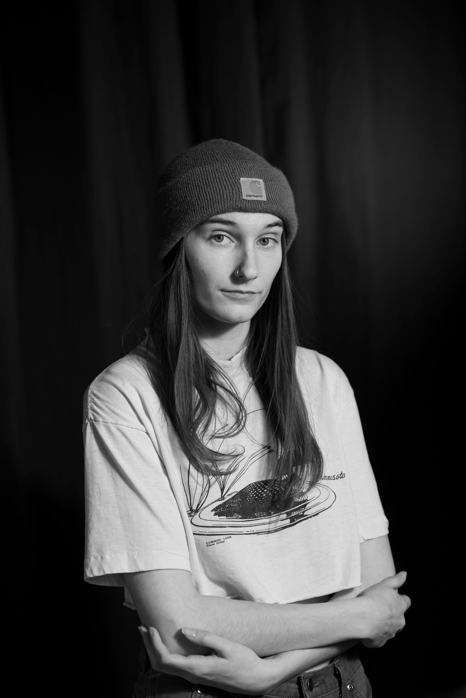 A dramatic black and white portrait series showing someone in a beanie hat and white t-shirt against a dark background.