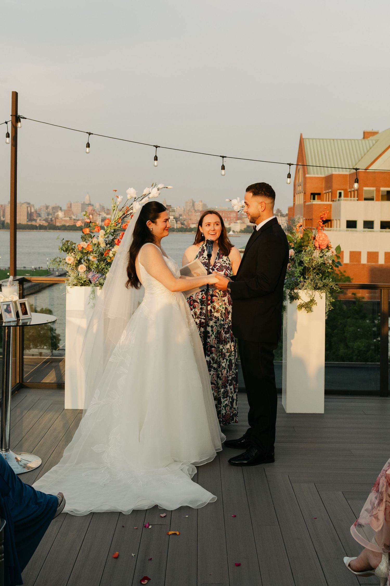 Rooftop wedding ceremony with city skyline backdrop and string lights.