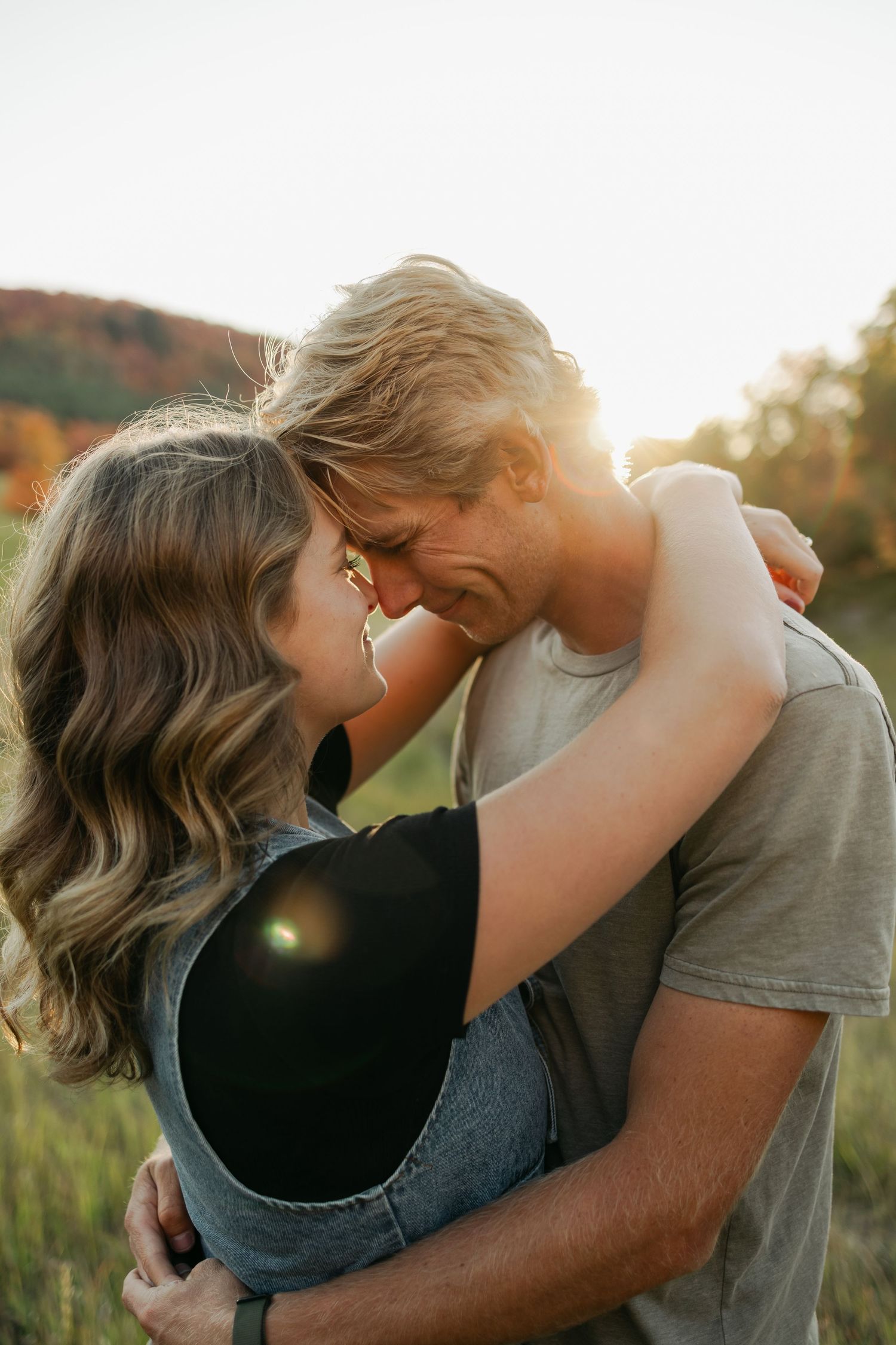 Romantic couple sharing intimate moments in a sunlit outdoor setting showing progression of tender embrace.