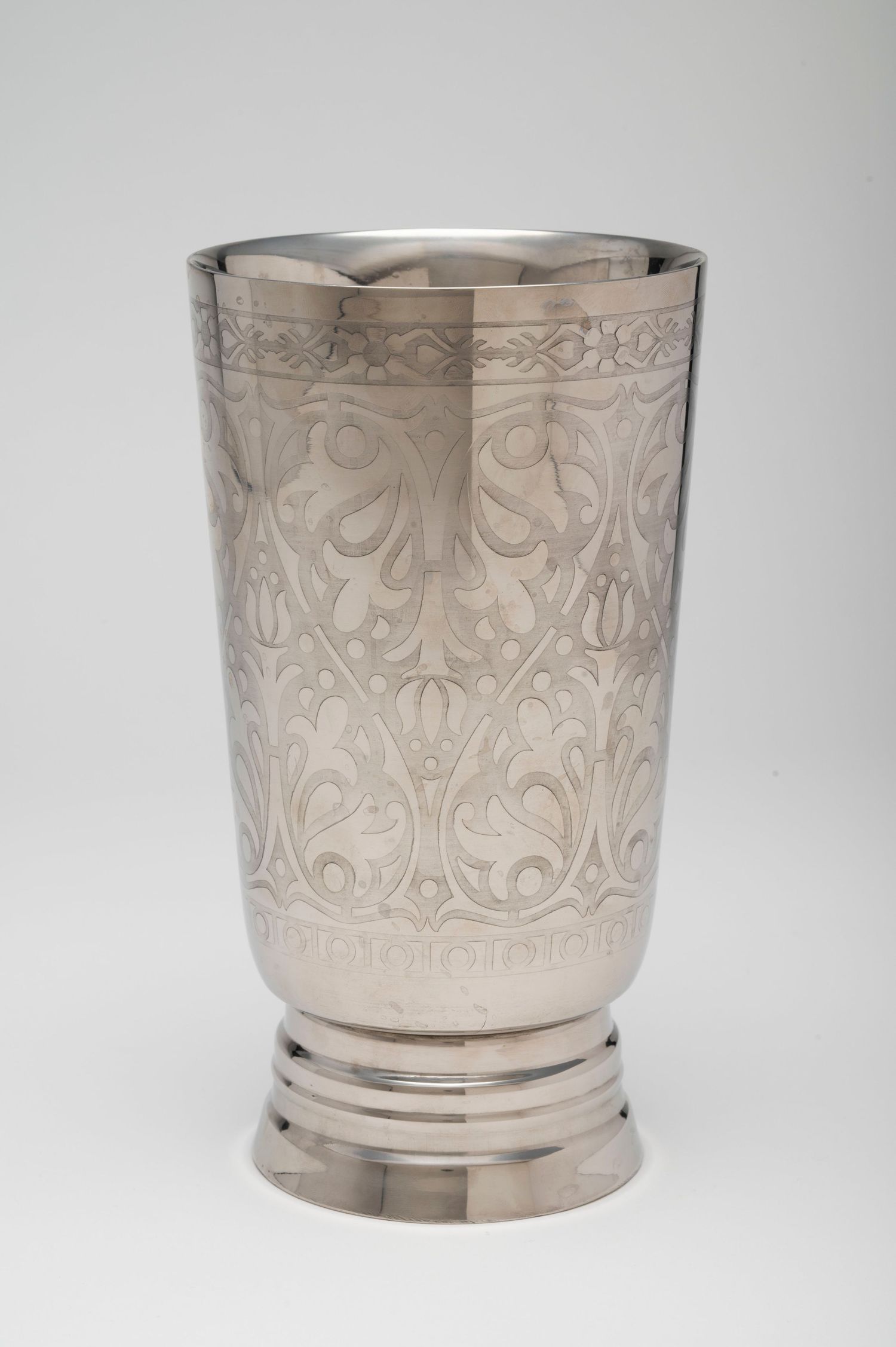 Antique silver napkin ring with intricate engraved floral and scroll pattern design shown from multiple angles.