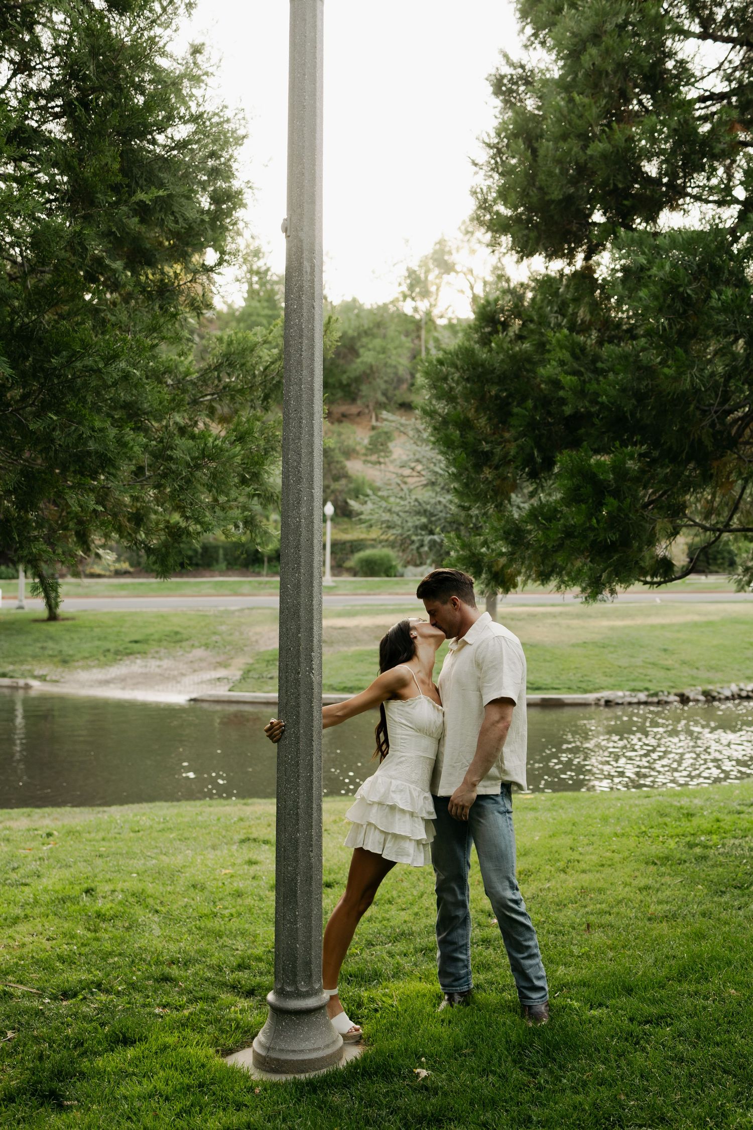 Three connected images showing a romantic moment between two people in a lush green park setting near a pond.