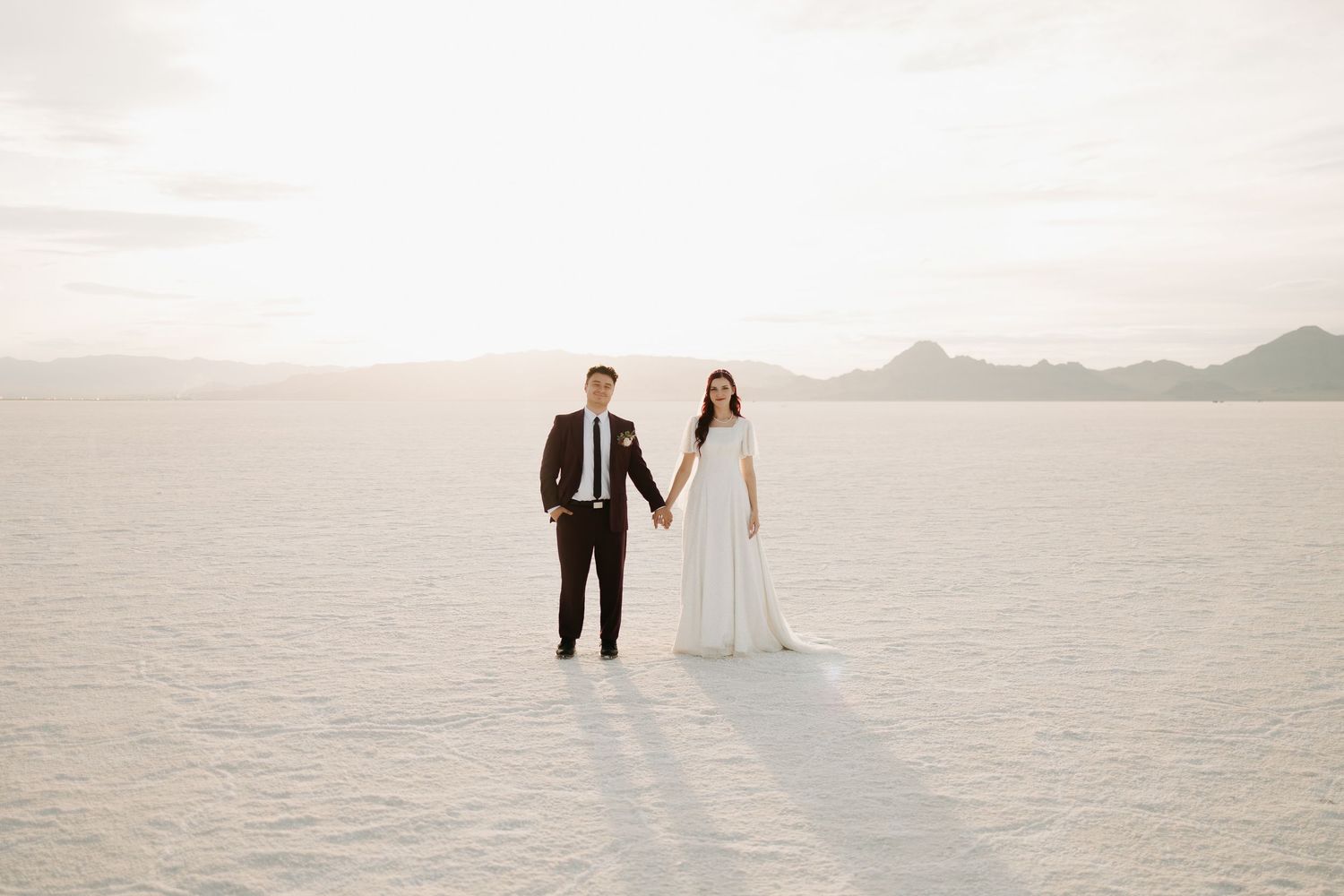 Minimalist wedding photos showing silhouettes against vast salt flats landscape.