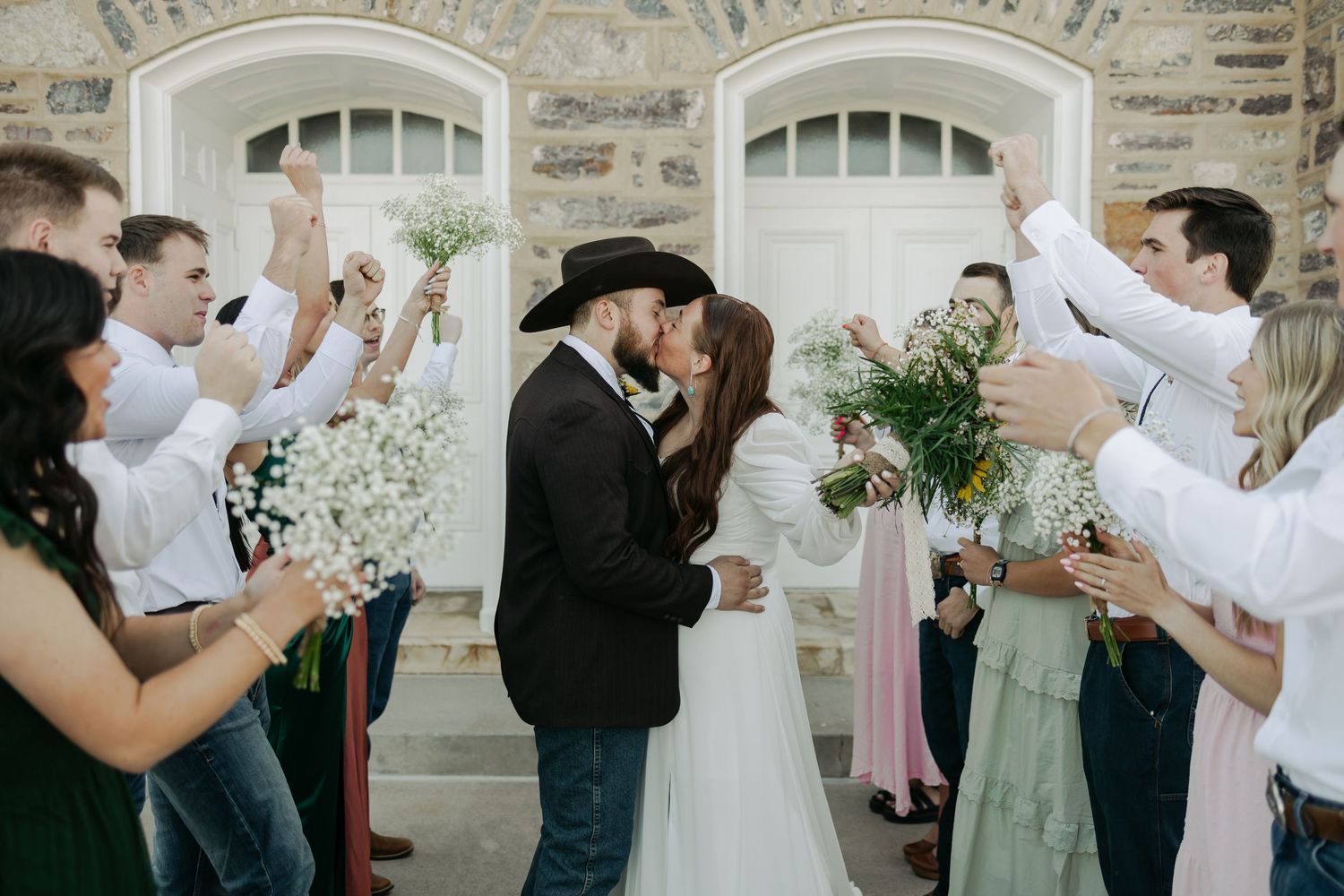 Wedding celebration with guests toasting and dancing at outdoor venue.