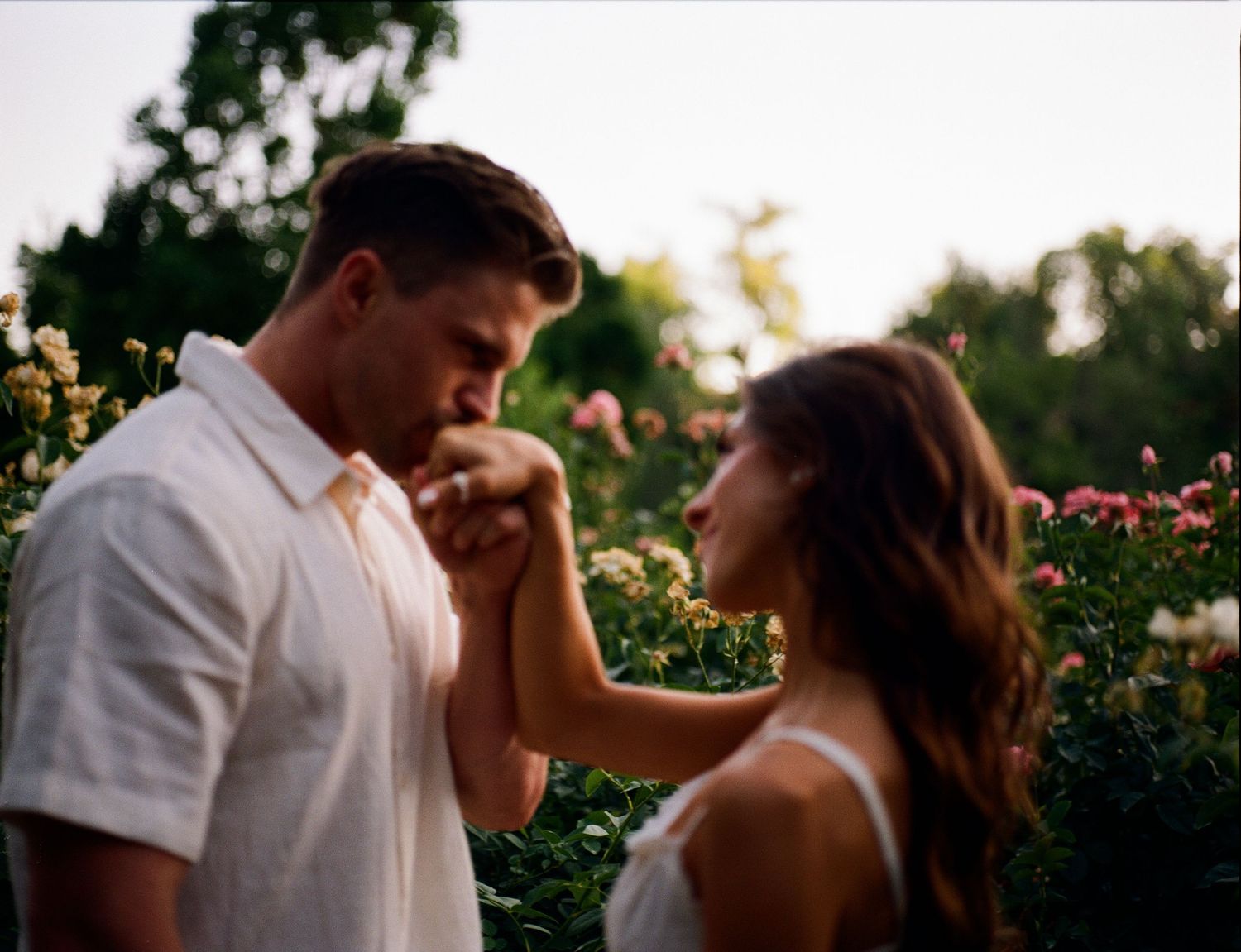 A sequence of romantic couple poses at sunset in a flower garden showing intimate moments and tender embraces.