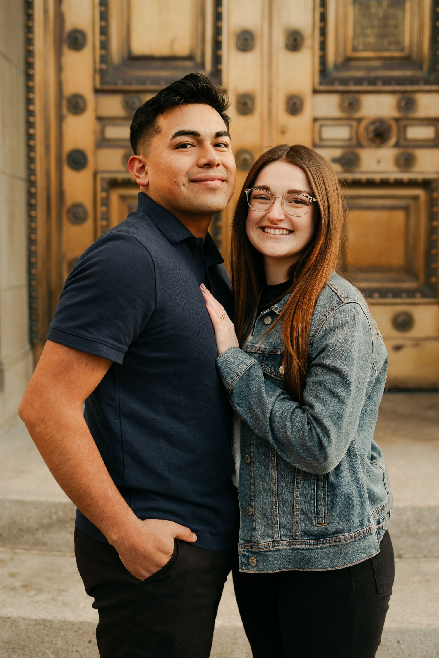 A couple in denim and black clothing share playful moments in a series of candid photos against an ornate wall.