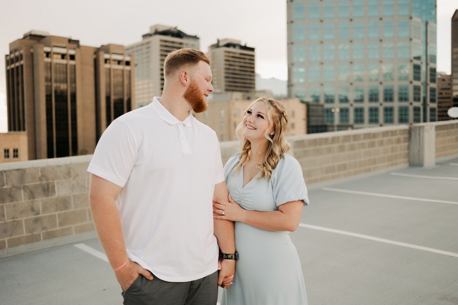 Couple sharing a candid moment on urban rooftop during sunset.