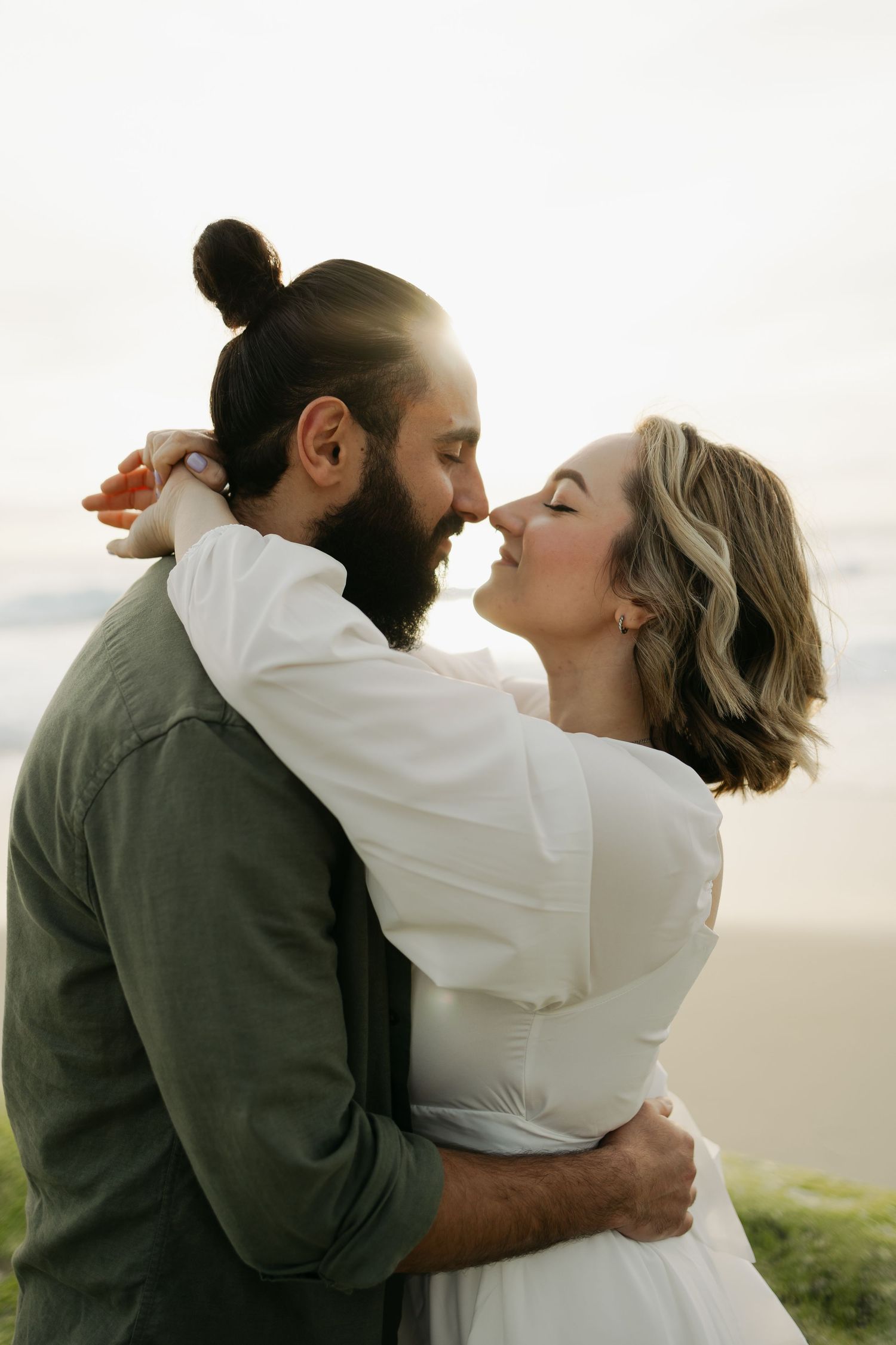 Intimate embrace captured during sunset with soft natural lighting.