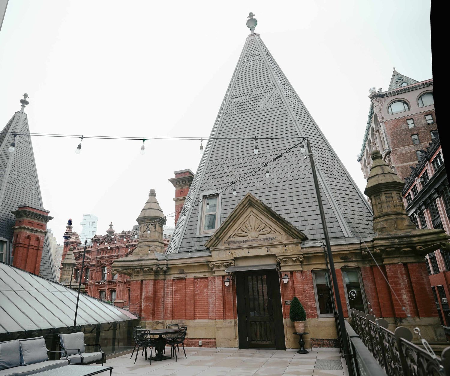 Victorian Gothic architecture features a distinctive steep gray spire and ornate details at Jefferson Market Library in New York.