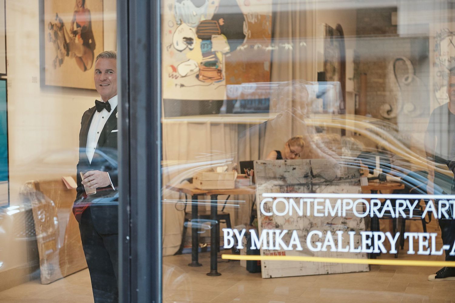 View through gallery window showing art space with Contemporary Art text on glass.