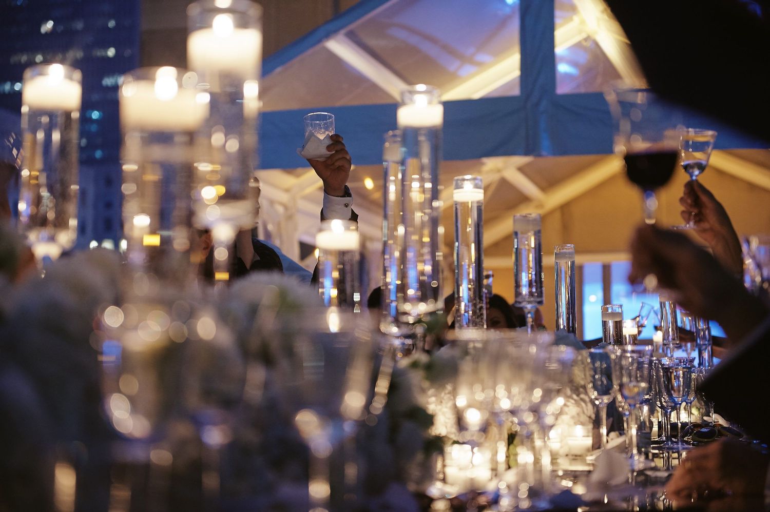 Crystal candlesticks and wine glasses create an elegant atmosphere at an upscale evening event.