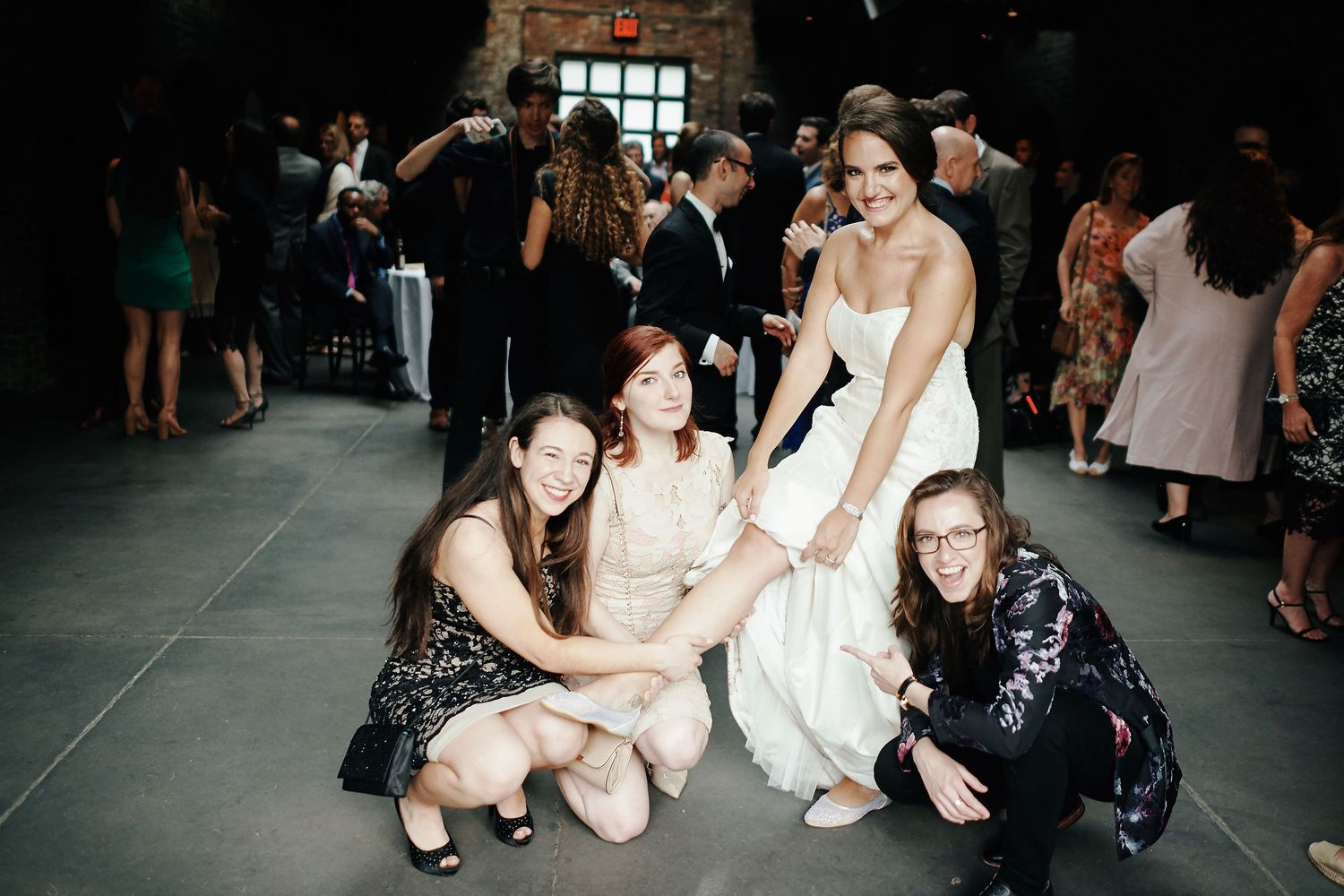 Wedding celebration features guests in formal attire gathering together at an indoor reception venue.