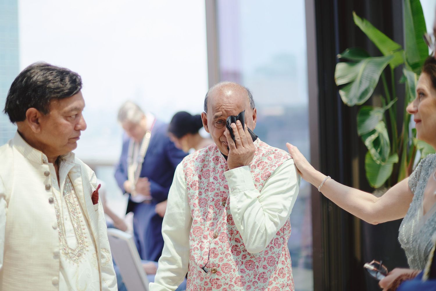 Candid emotional moment between guests at wedding celebration.