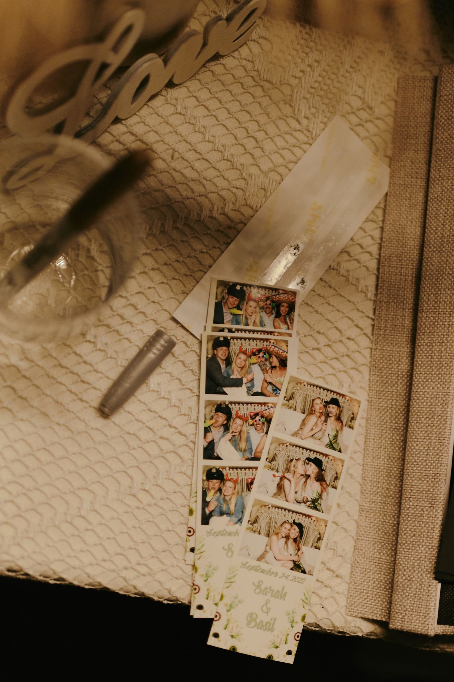 A vintage sepia-toned photo strip lies on a textured surface next to a pen and paper.