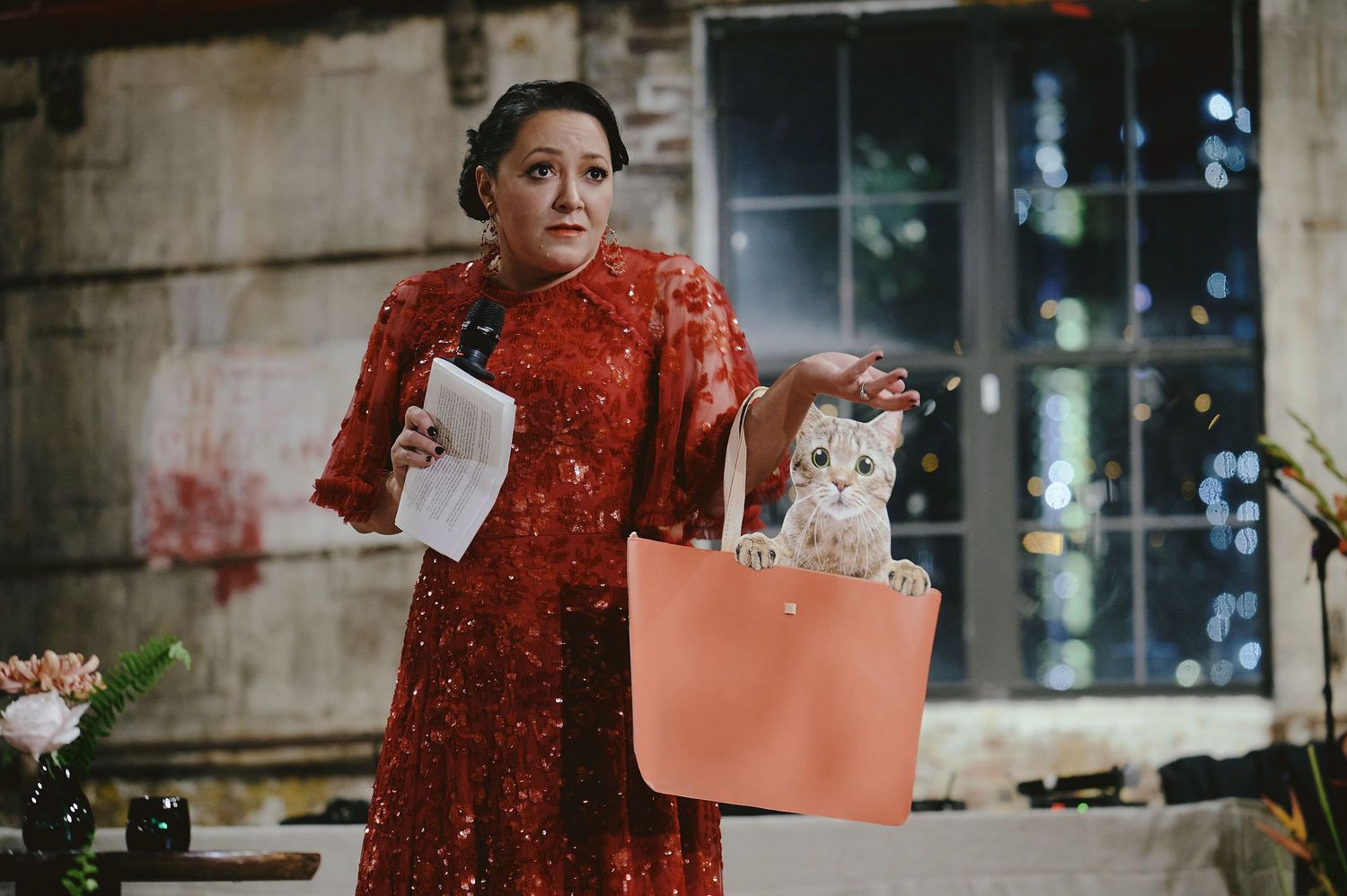 Someone in a traditional red cheongsam dress holds a shopping bag with a white cat peeking out.