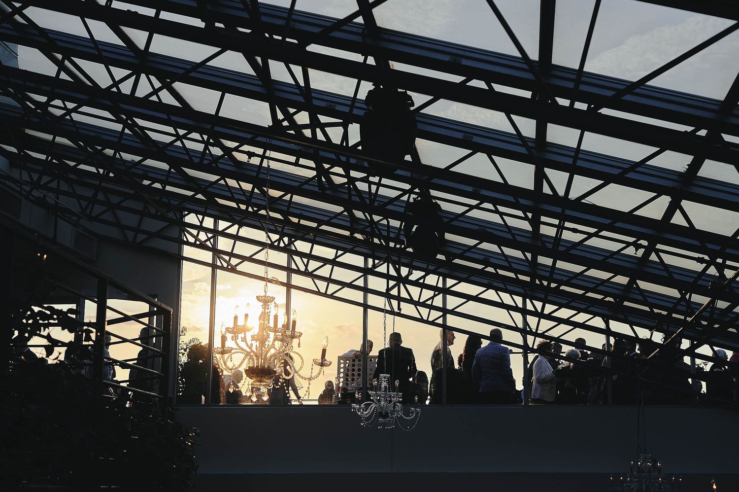 Silhouette of a stage or industrial structure with sunlight peeking through at sunset creating a dramatic backlit effect.