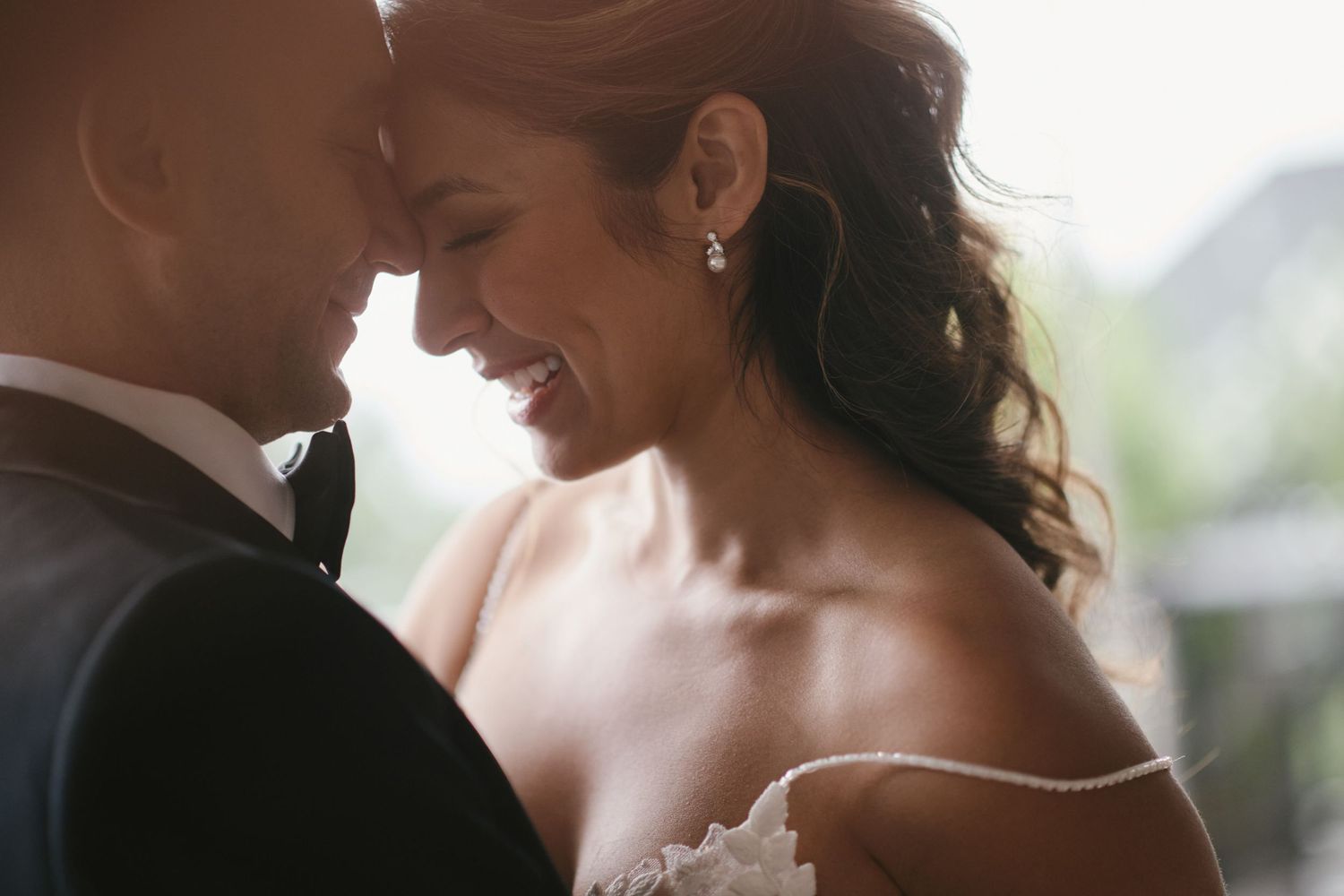 Intimate close-up of newlyweds sharing a tender moment in natural light.