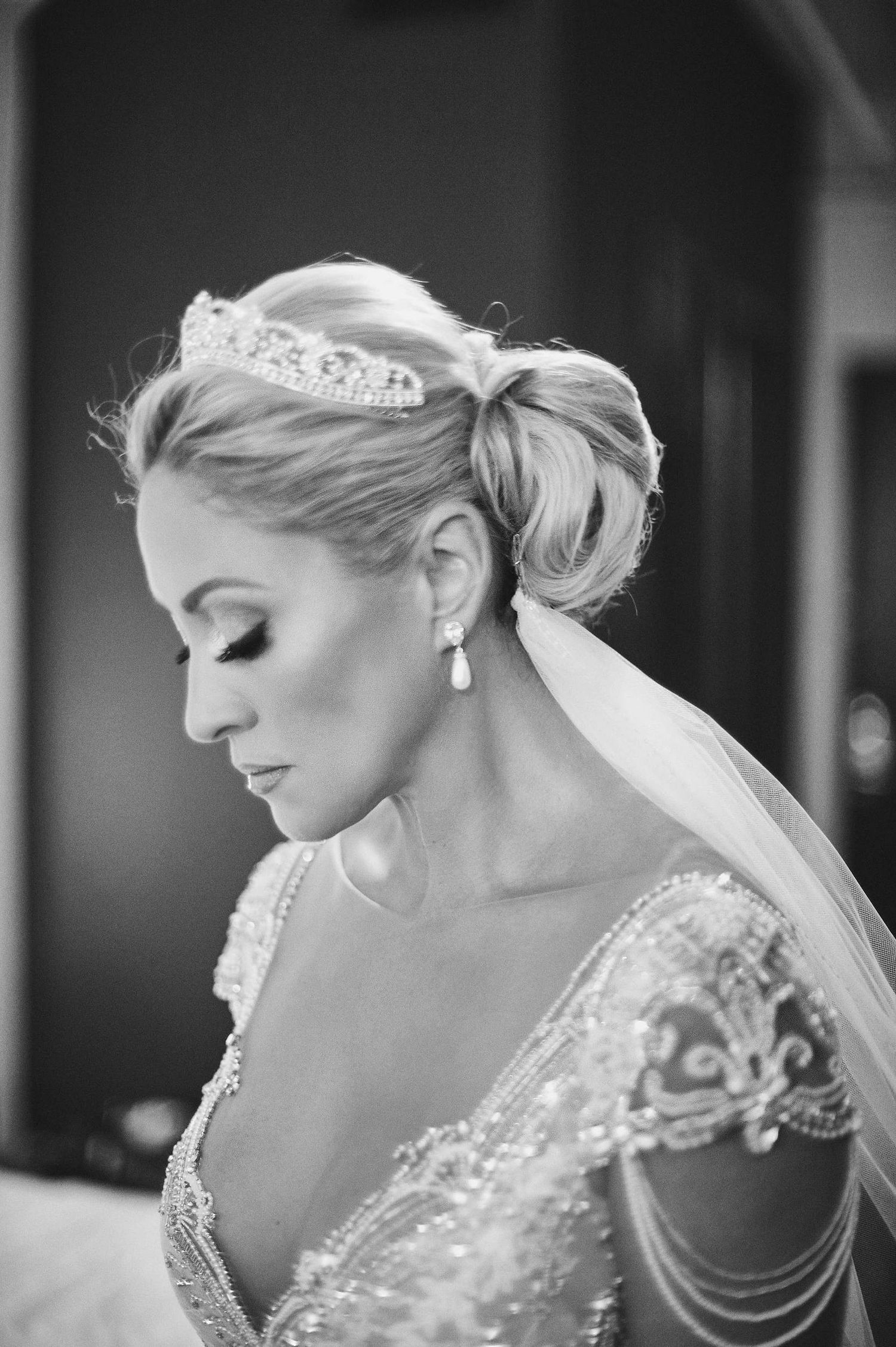 Beautiful bridal portrait in black and white featuring an elegant updo hairstyle with tiara, veil and delicate beaded dress details.