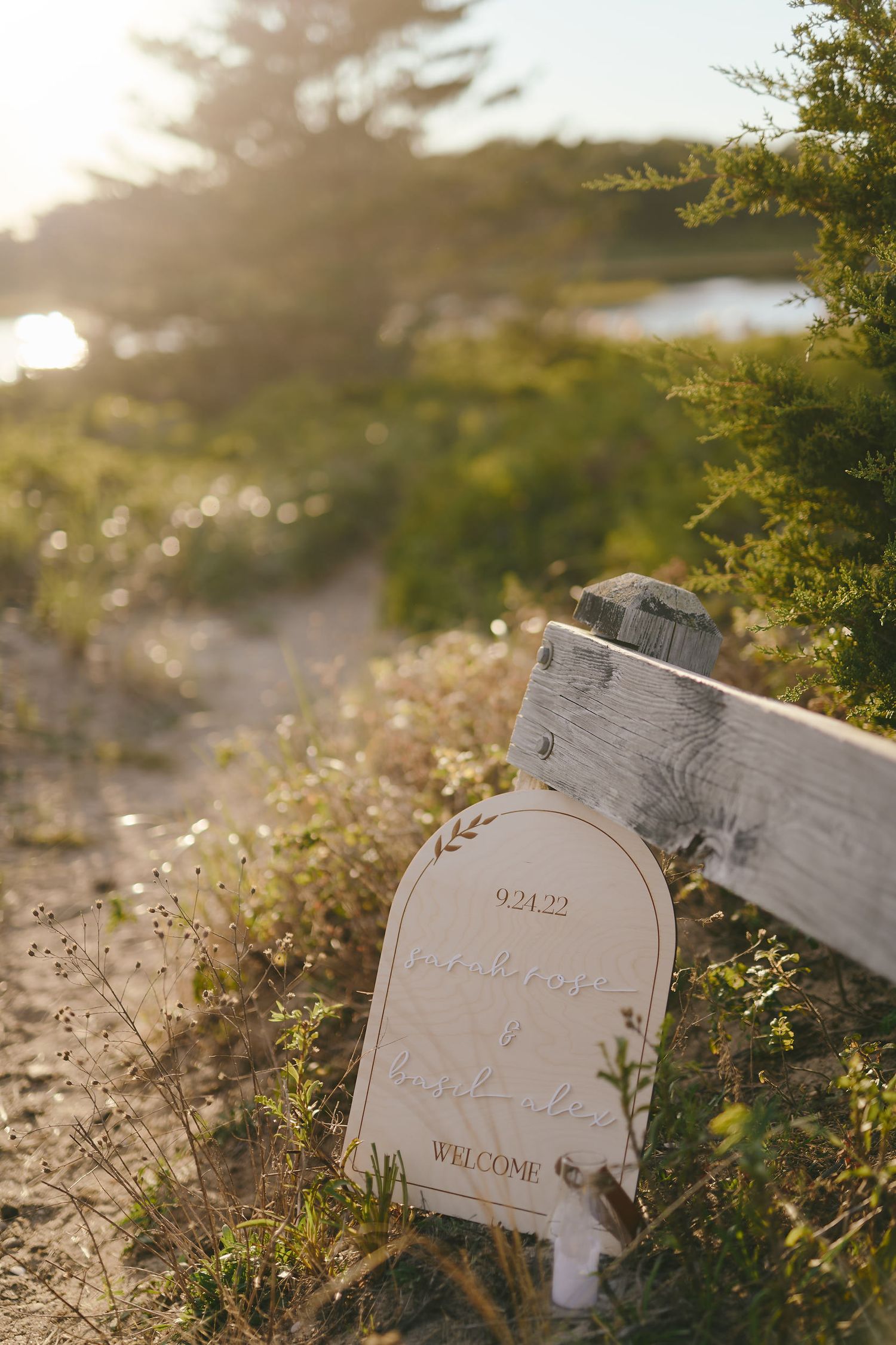 A weathered mailbox stands among wildflowers and grass at sunset, creating a nostalgic rural scene.