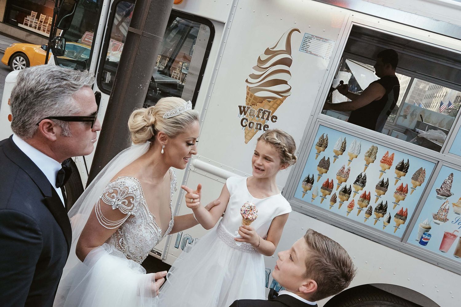 Wedding party gathered around an ice cream truck on their special day.