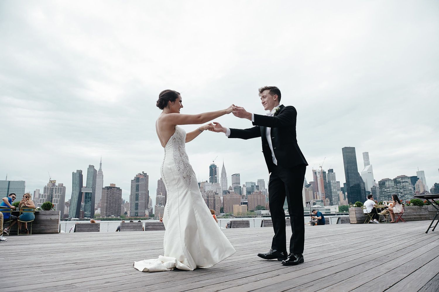A couple shares a romantic dance moment on a rooftop with the Manhattan skyline as their backdrop.