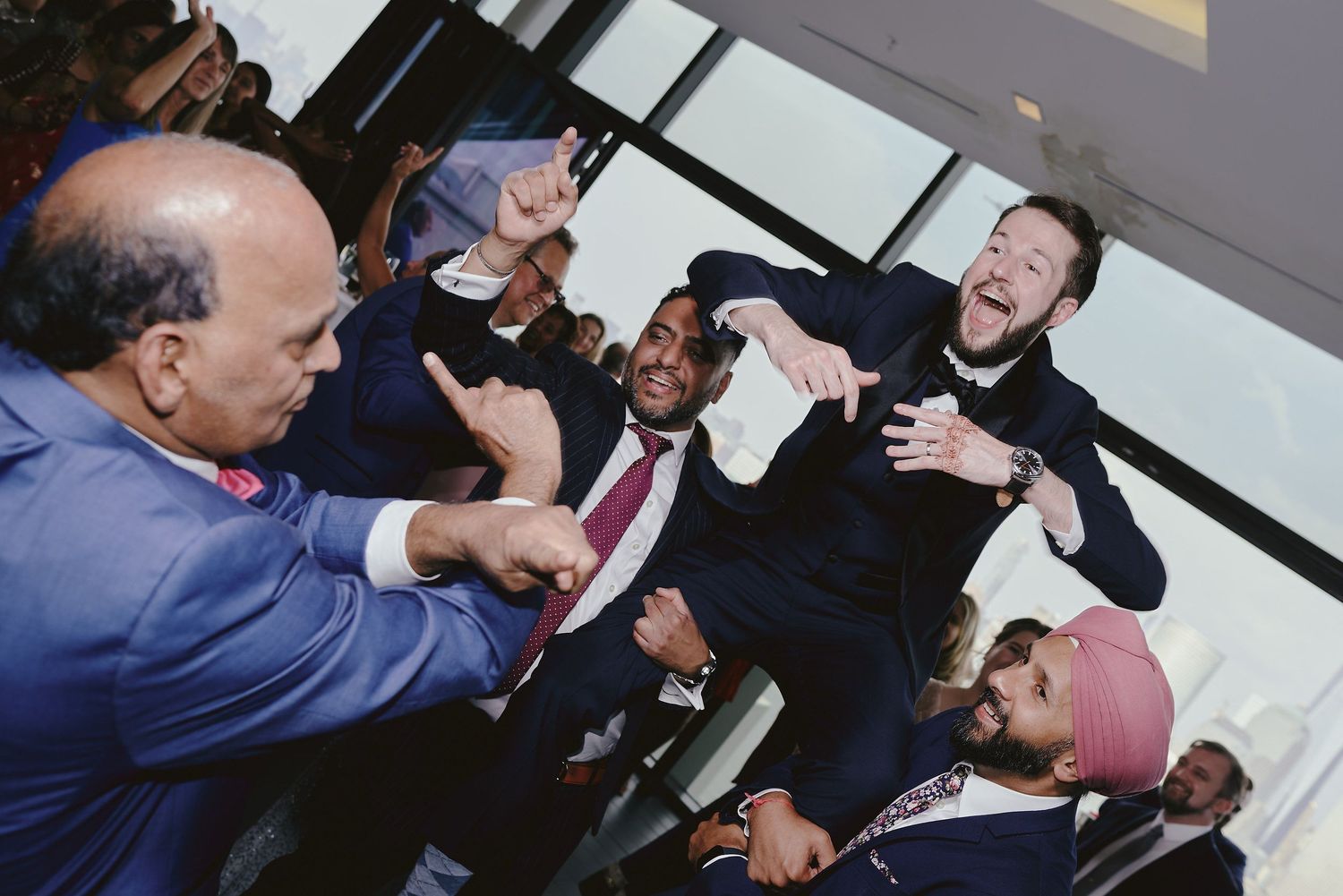 A group of people share an animated moment of laughter and conversation in an indoor setting.