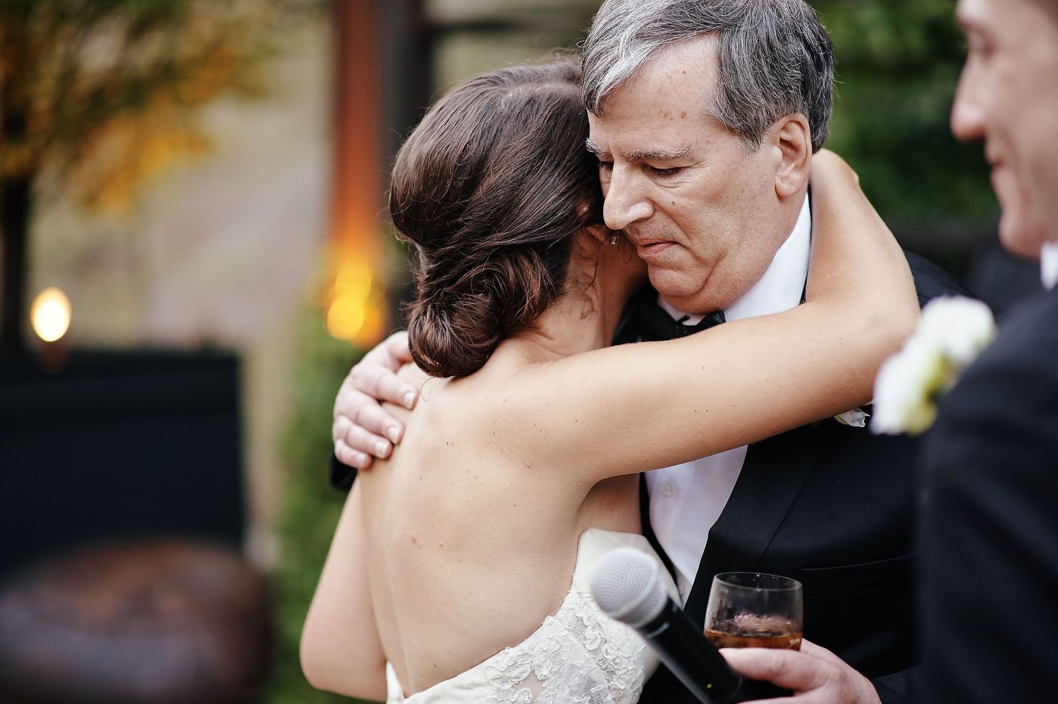 Two people share an intimate embrace during a formal evening wedding celebration.