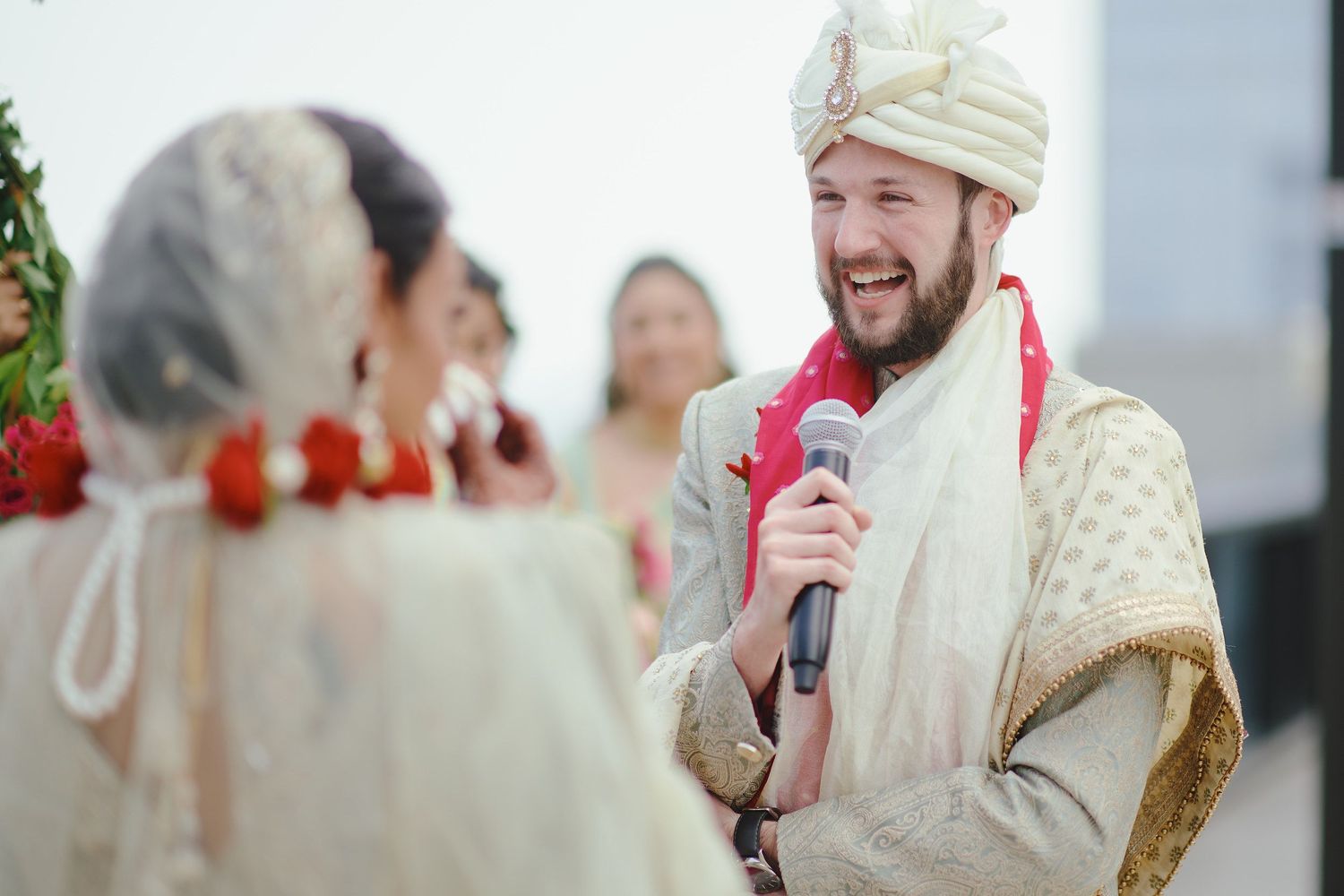 A candid moment during a wedding ceremony with a microphone and festive traditional outfits.