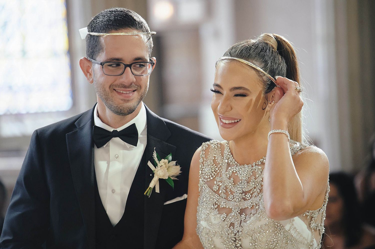 A couple sharing a joyful moment together during an elegant indoor celebration.