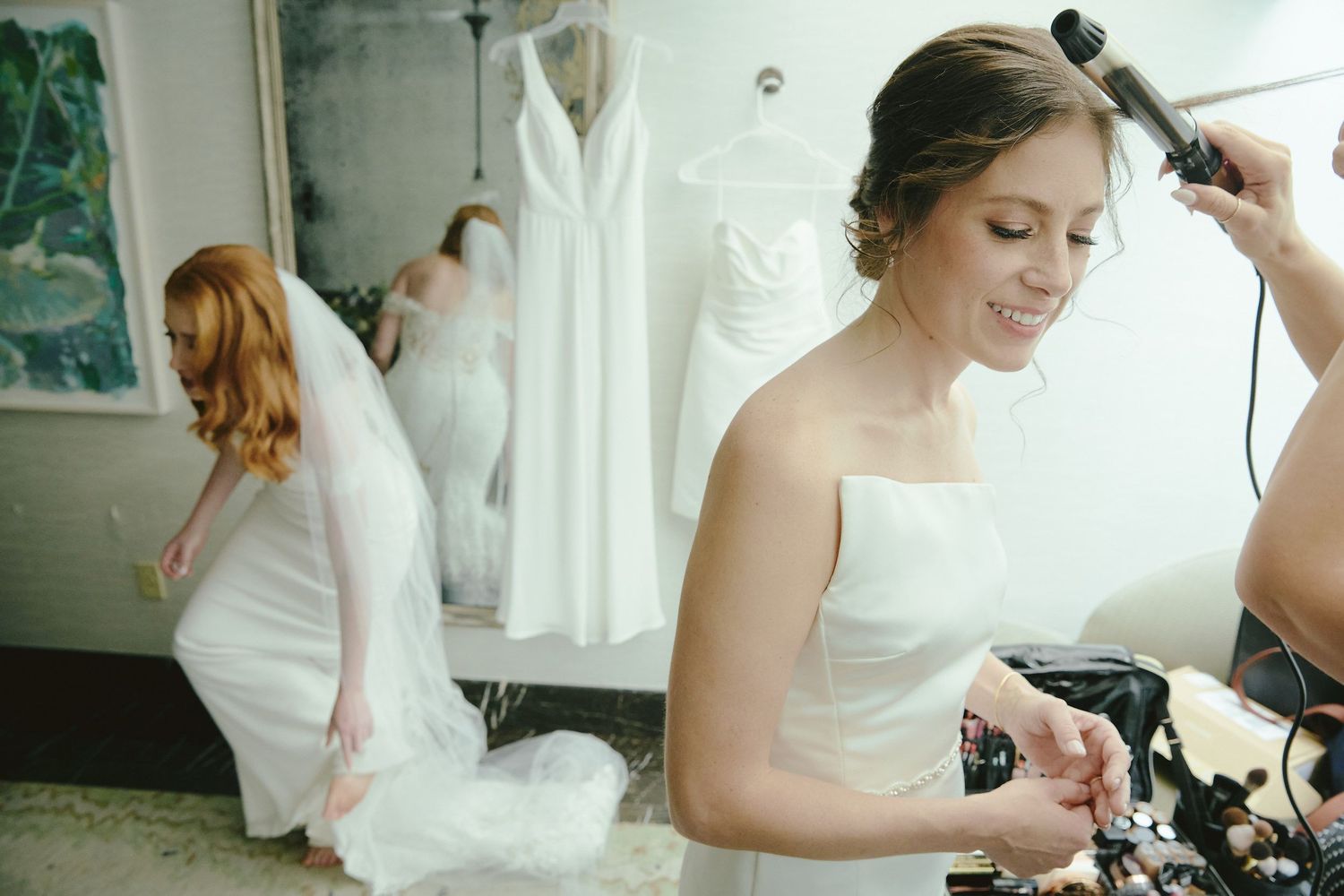 A wedding preparation scene showing dress alterations and styling in a bright dressing room.
