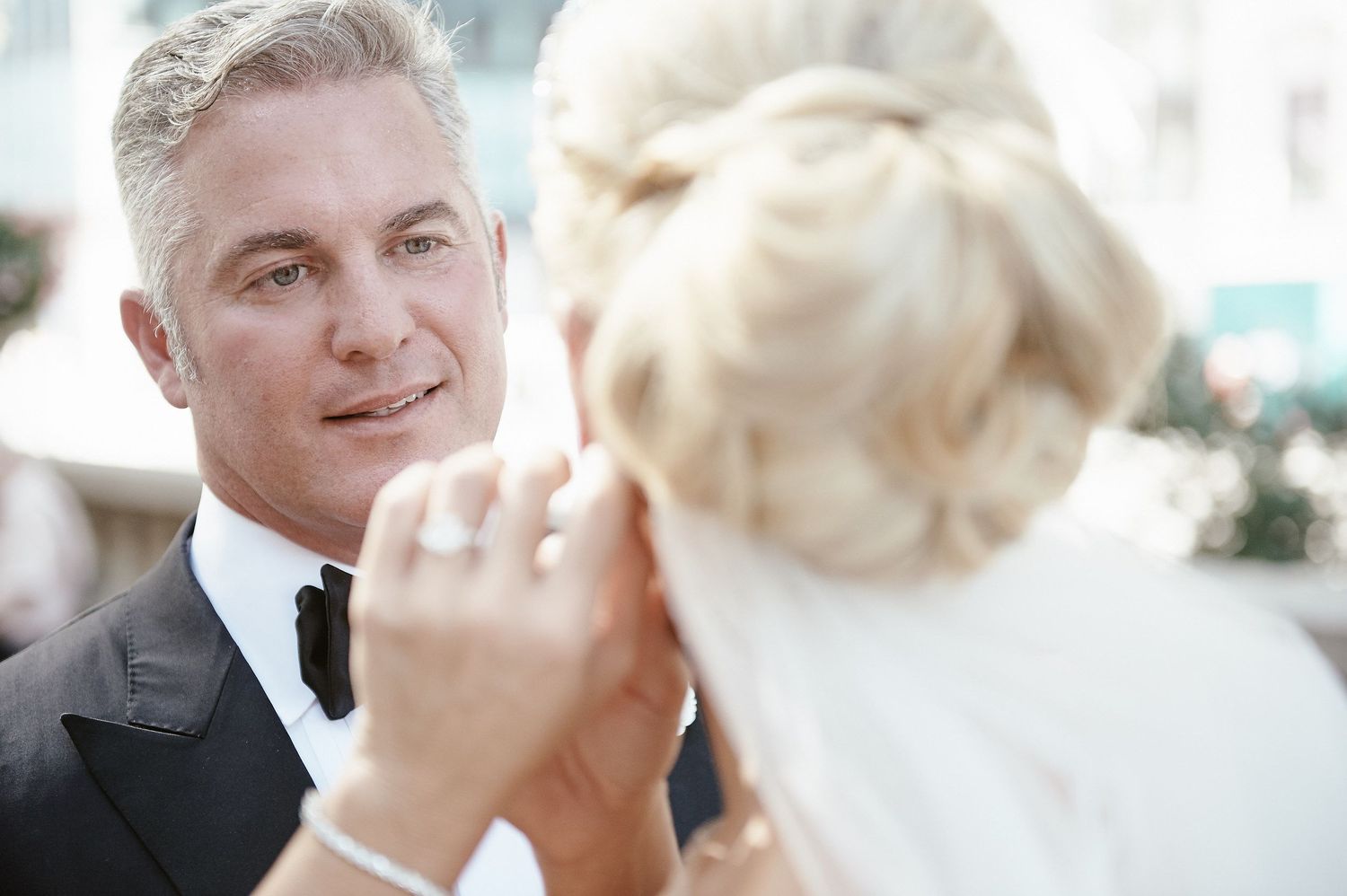 Close up view of a romantic wedding moment captured outdoors with soft lighting and bokeh background.