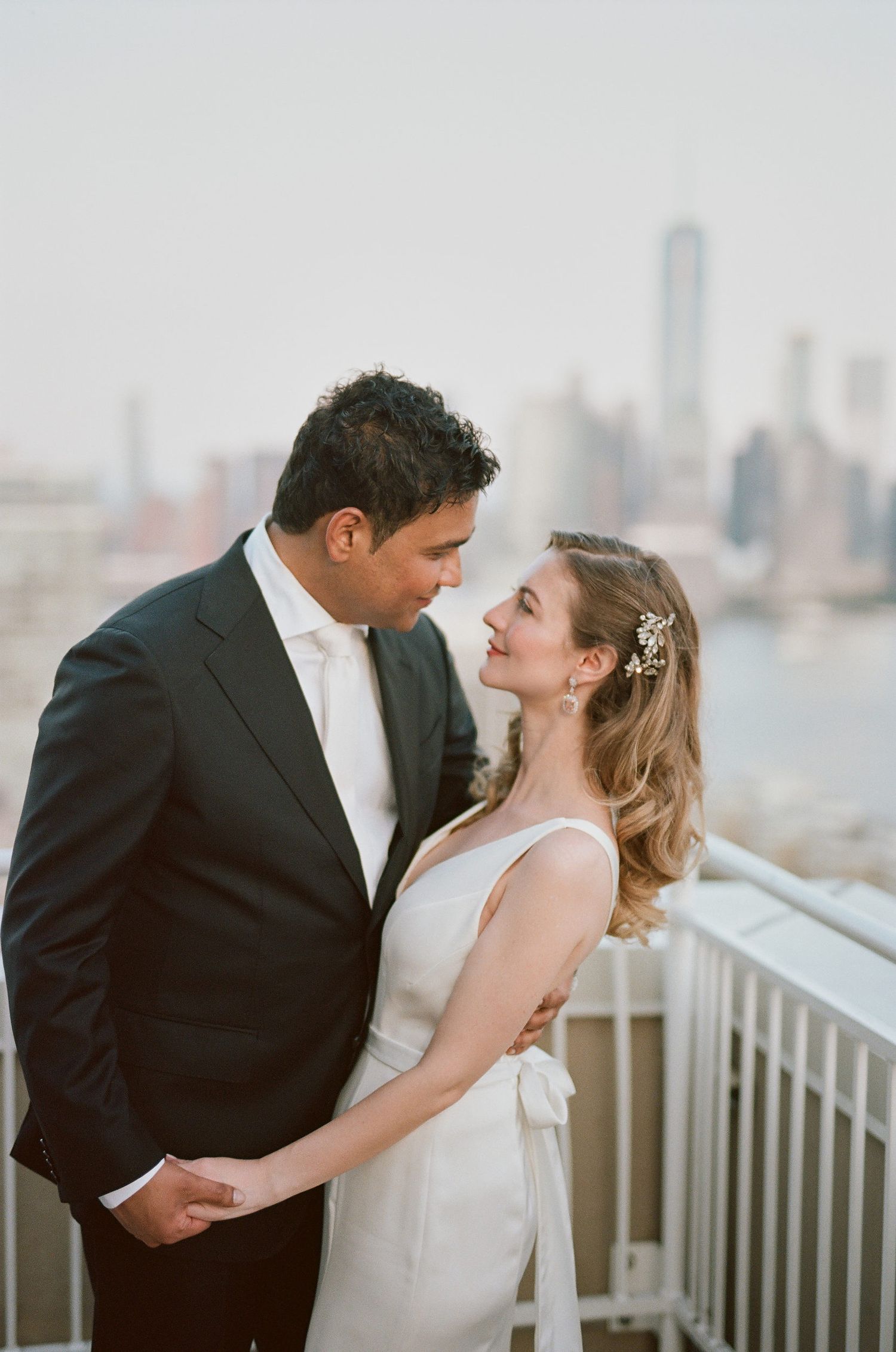 Romantic couple embracing with Manhattan skyline view in background.