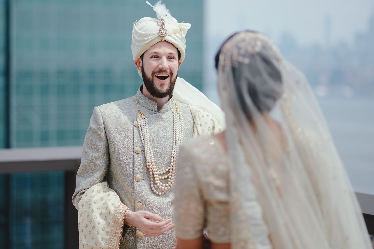 Emotional wedding moment captured between newlyweds against city backdrop.