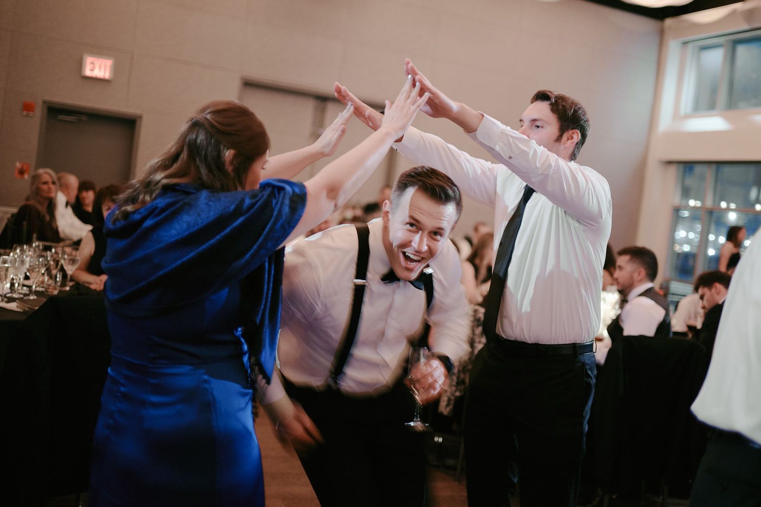 Guests dancing and celebrating with high energy at a wedding reception on the dance floor.