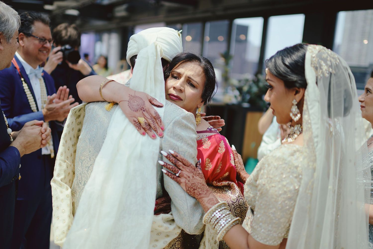 Emotional wedding celebration moments with family members embracing during traditional Indian ceremony.