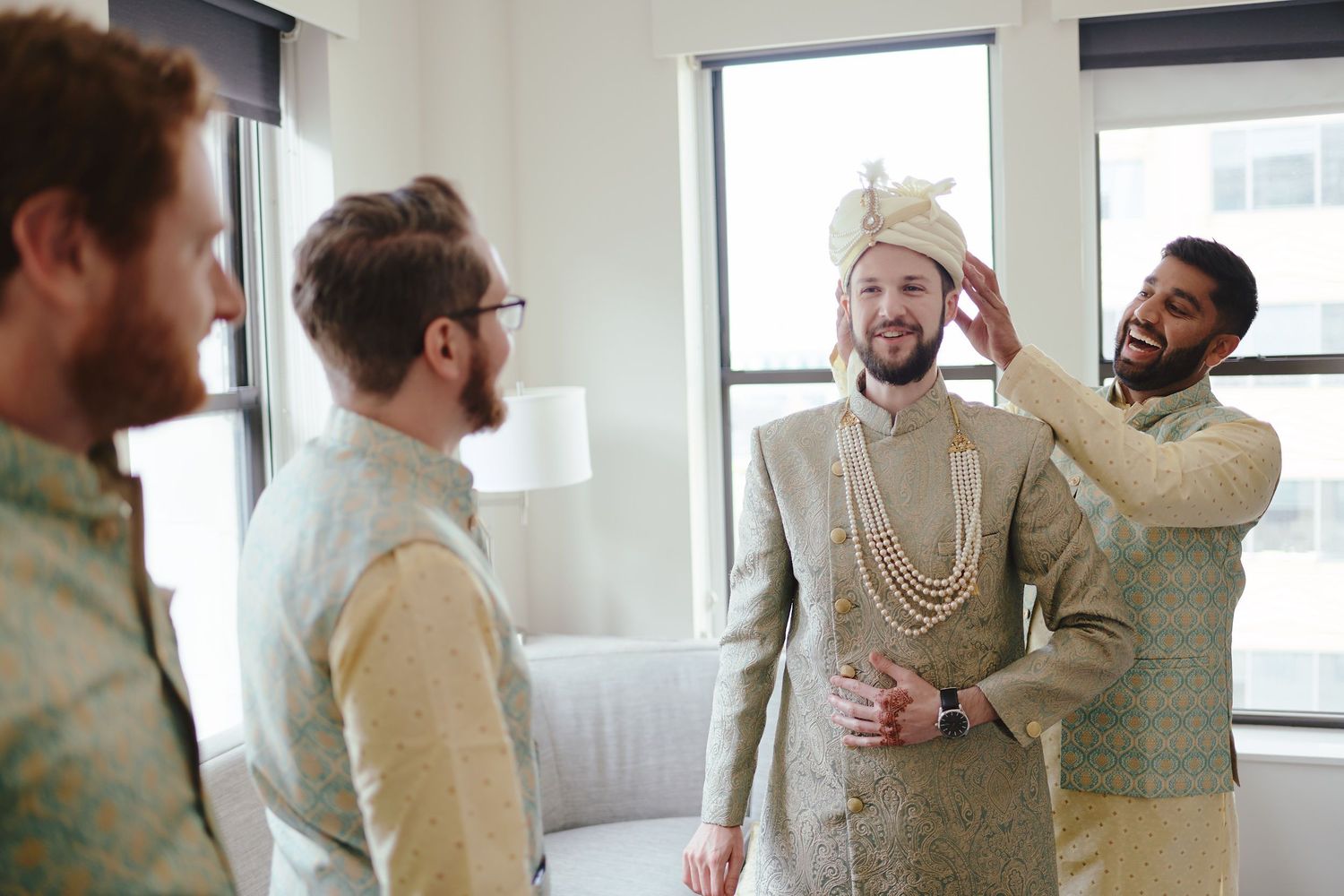 A group of friends share a lighthearted moment getting ready for a traditional Indian wedding celebration.