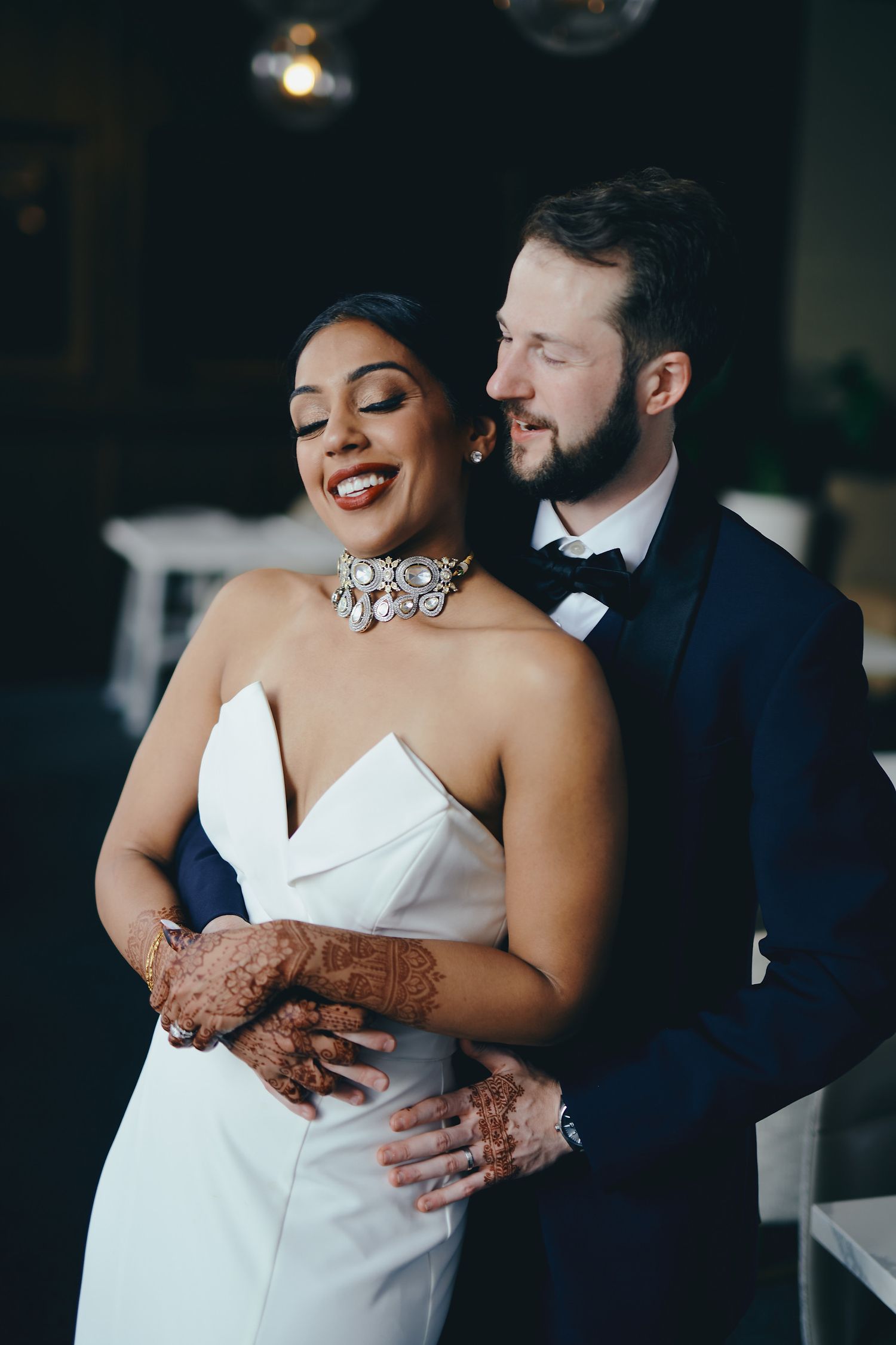 A romantic moment between newlyweds as they embrace in formal wedding attire.