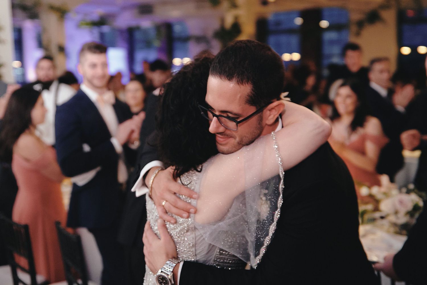 A tender moment between a couple embracing on the dance floor at an elegant wedding reception.