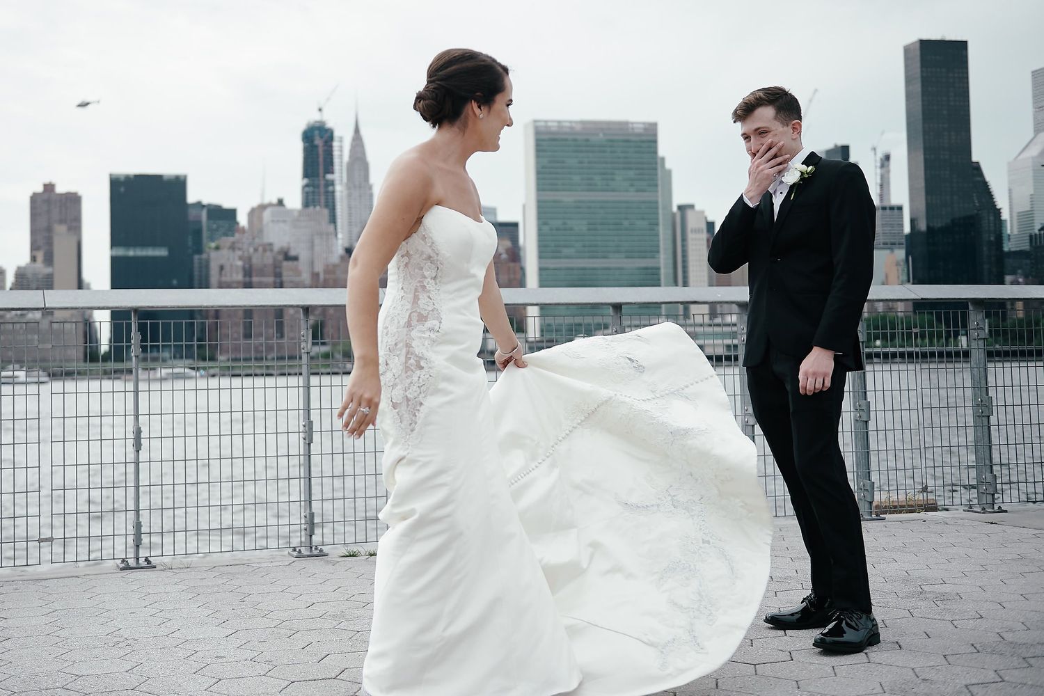 A couple shares a wedding moment on a rooftop with the Manhattan skyline in the background.