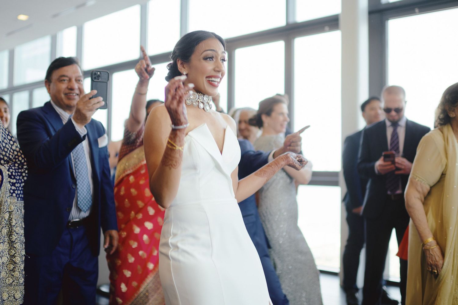 An enthusiastic celebratory scene at a wedding reception with attendees dancing and enjoying the festive atmosphere.
