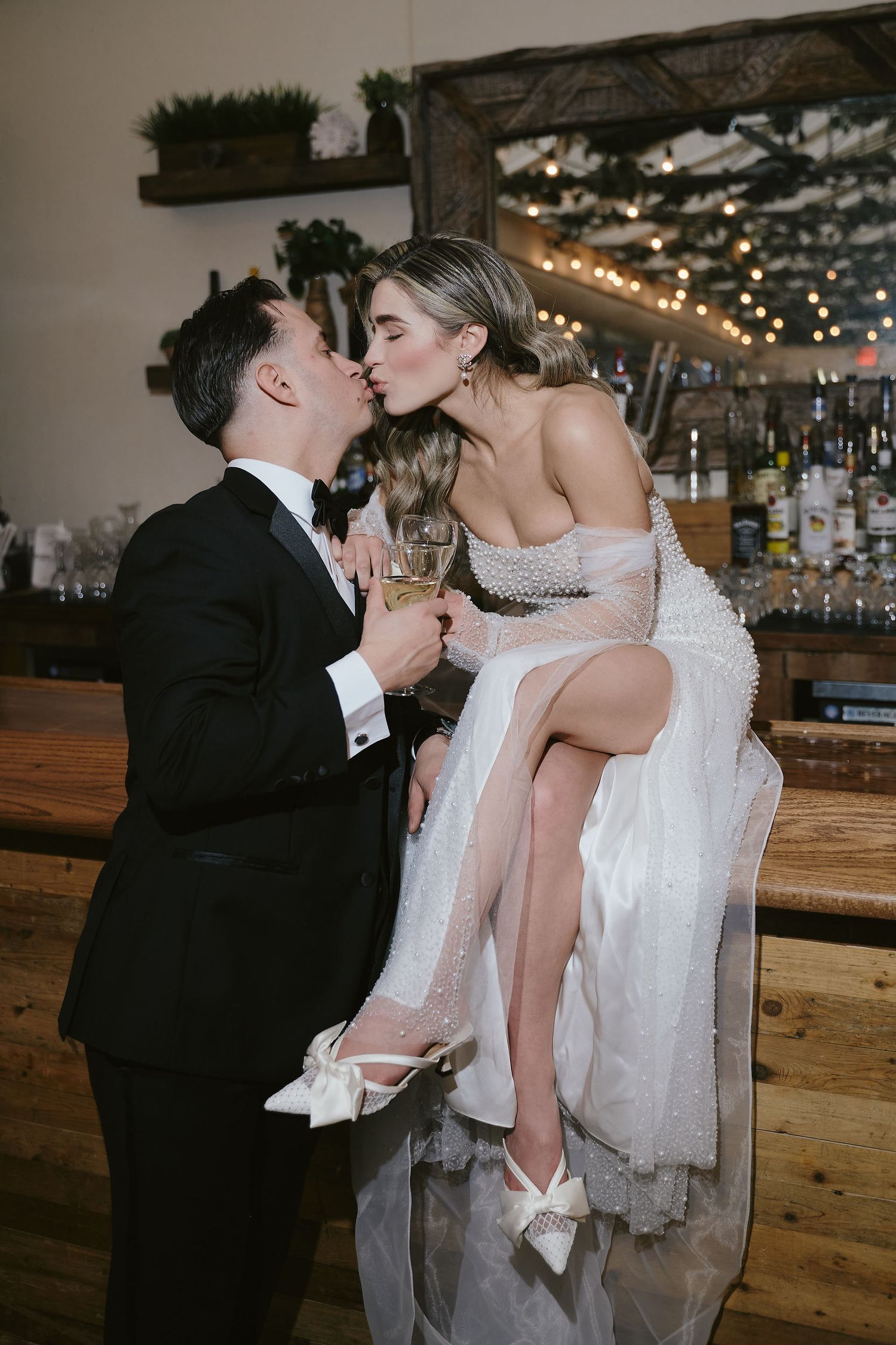 A romantic moment between newlyweds sharing a kiss at the bar during their wedding reception.