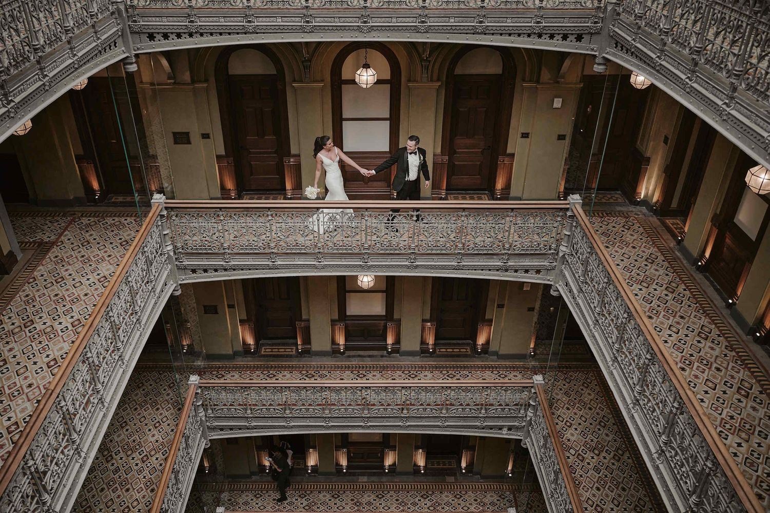 Ornate interior balconies with intricate metalwork and columns inside a historic Victorian-era building.