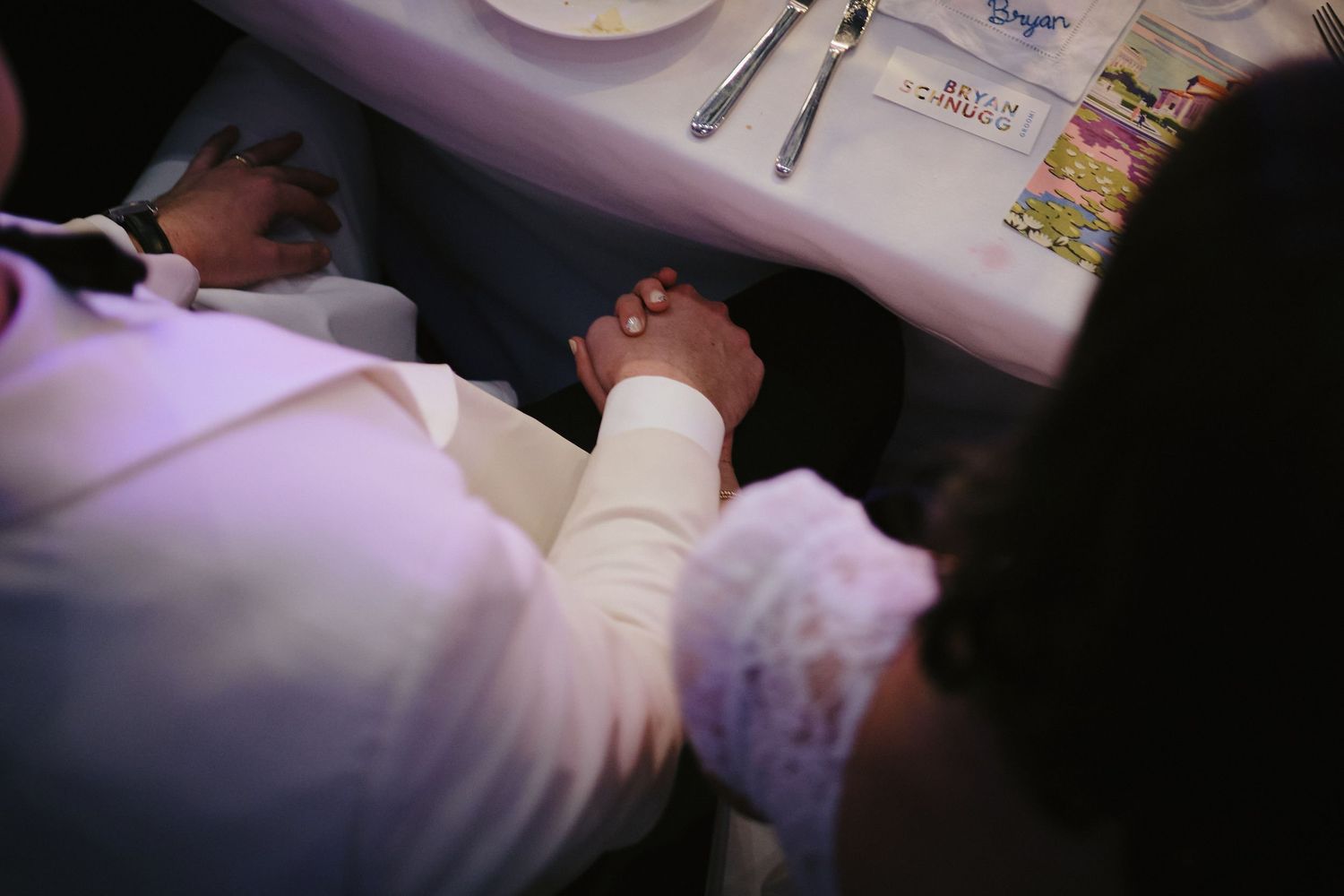 A hand wearing a hospital bracelet rests on a white surface during a medical visit.
