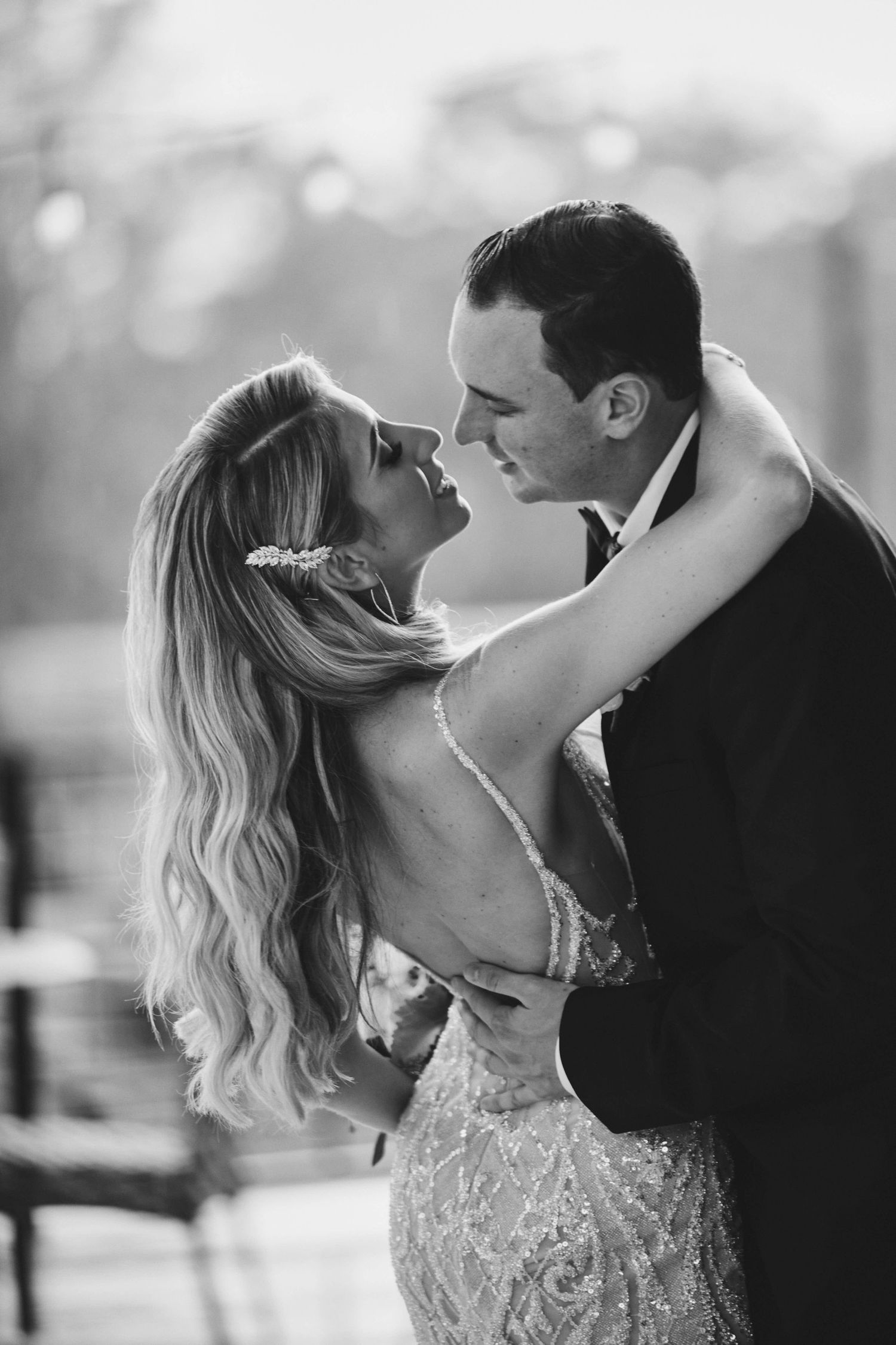 A romantic black and white wedding photo of a couple in an intimate embrace on the dance floor.