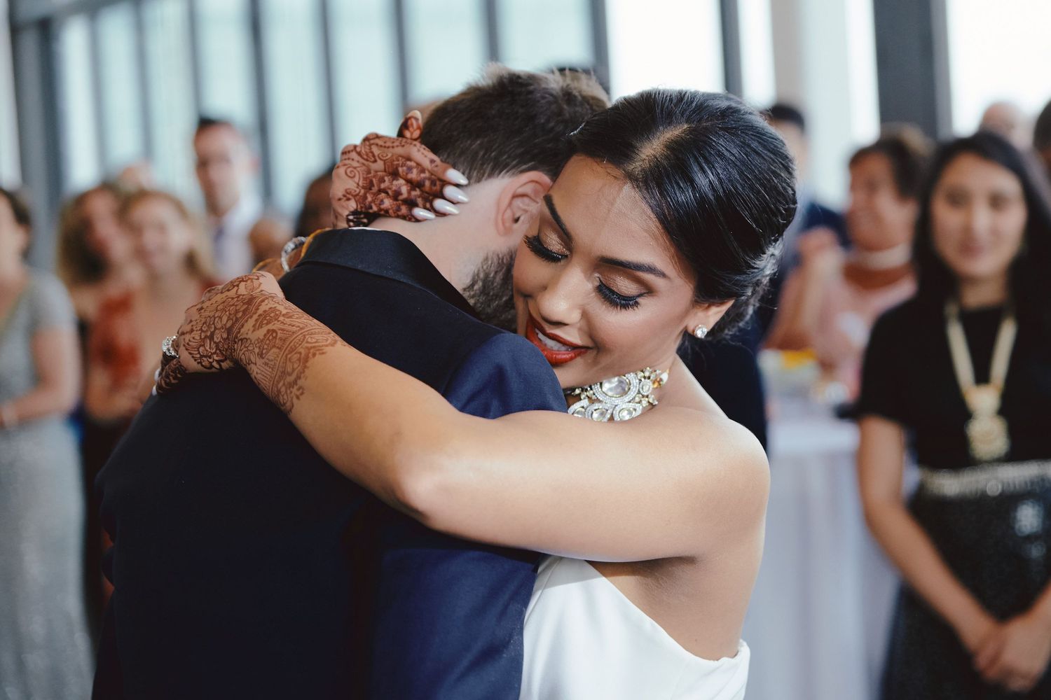 A tender embrace between newlyweds during their first dance at an elegant reception venue.