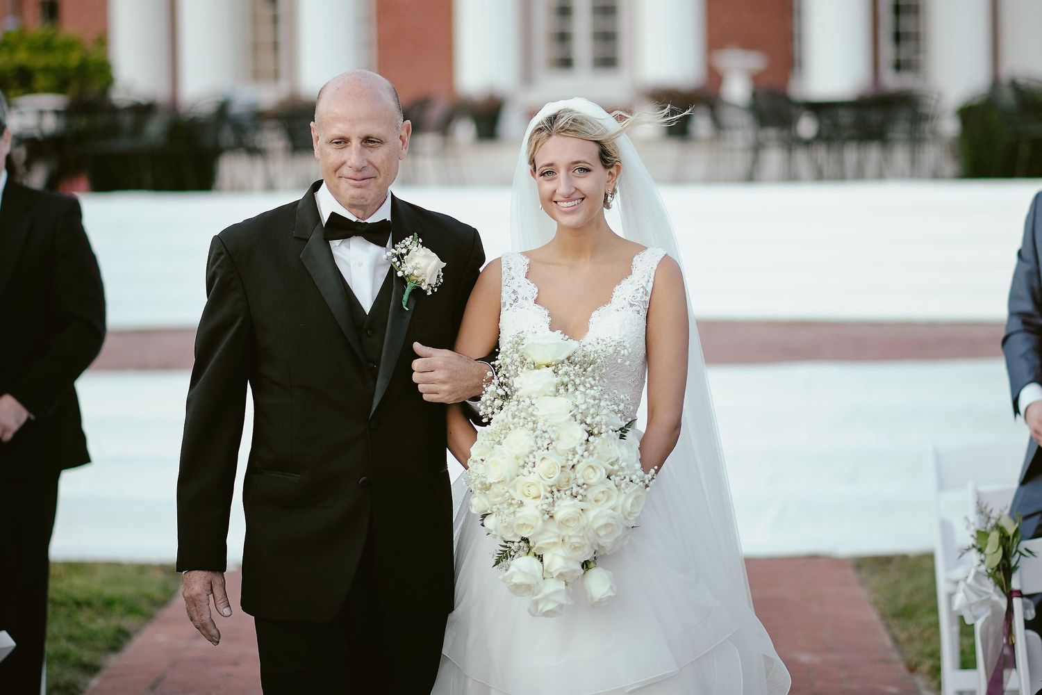 An elegant wedding ceremony processional on a white walkway.